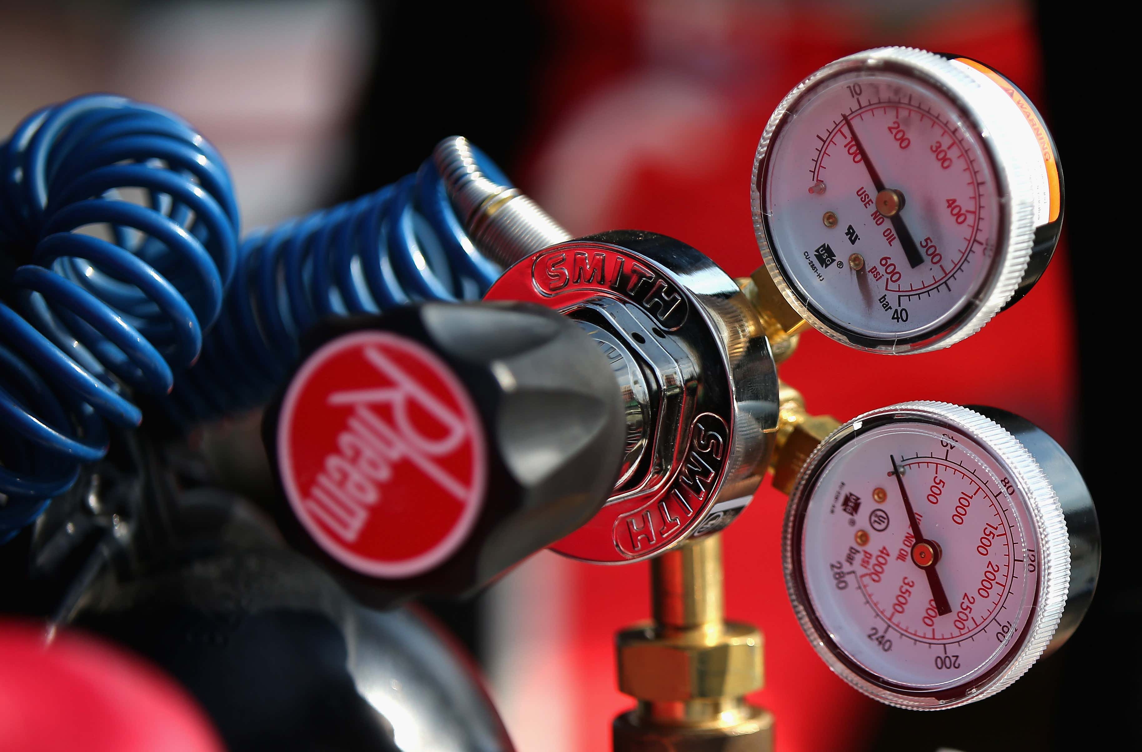 An air compressor gauge with a red knob 带红色旋钮的空气压缩机仪表