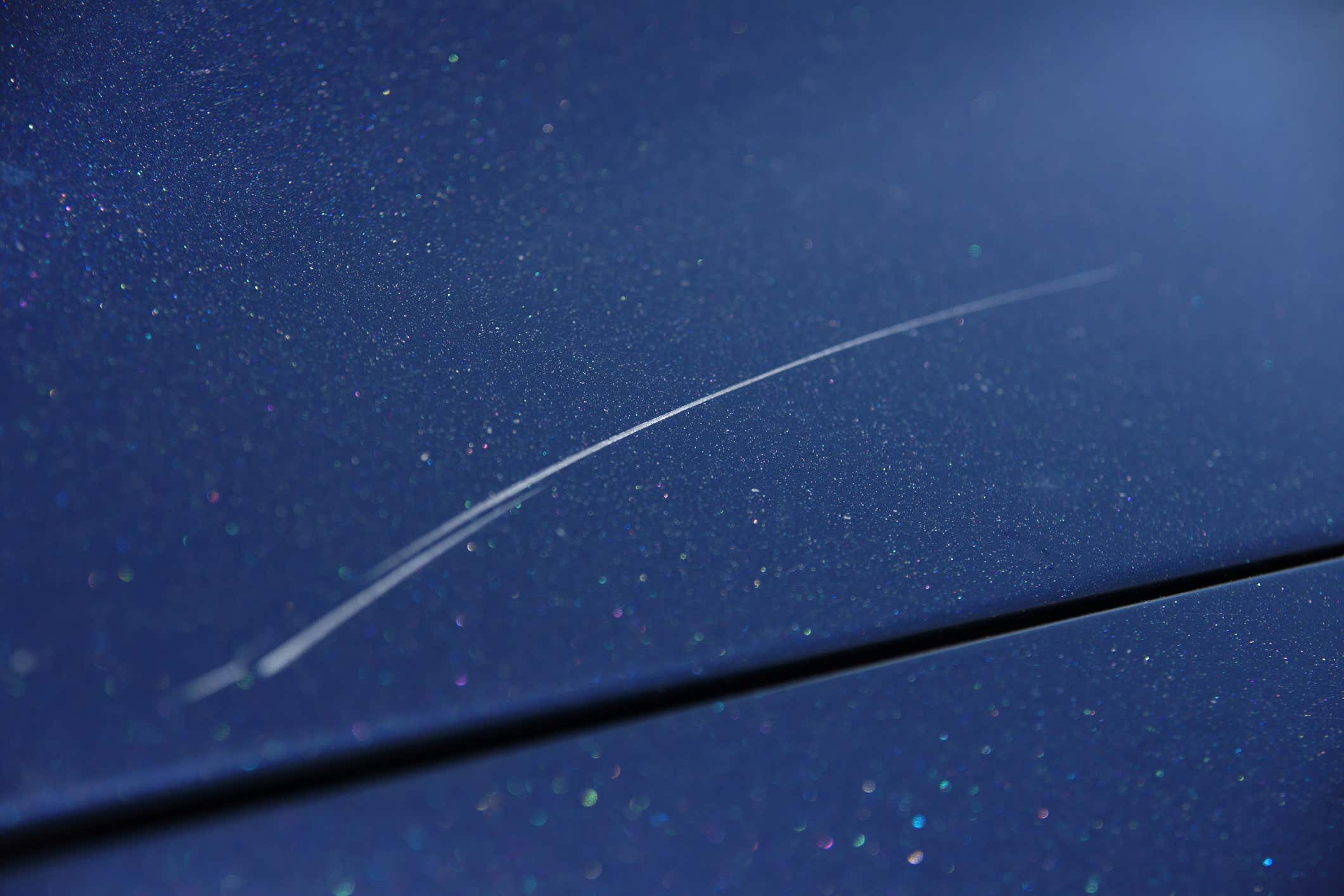 Light scratch on a blue car 在一辆蓝色汽车的轻的划痕