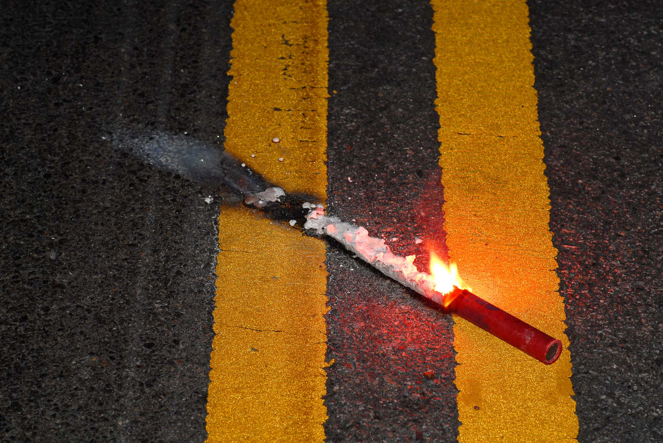 Close up road flare on pavement 关闭在路面的路耀斑