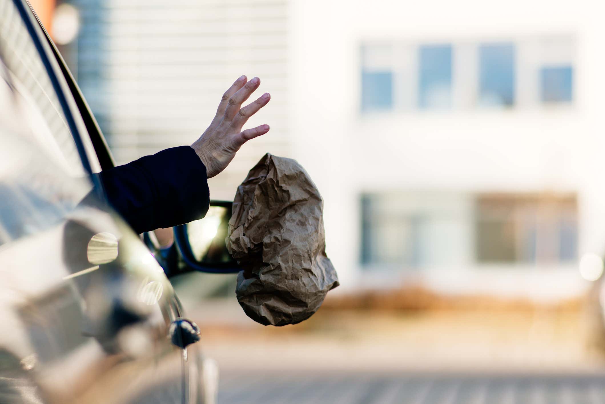 Passenger throwing garbage out car window 乘客向车窗外扔垃圾