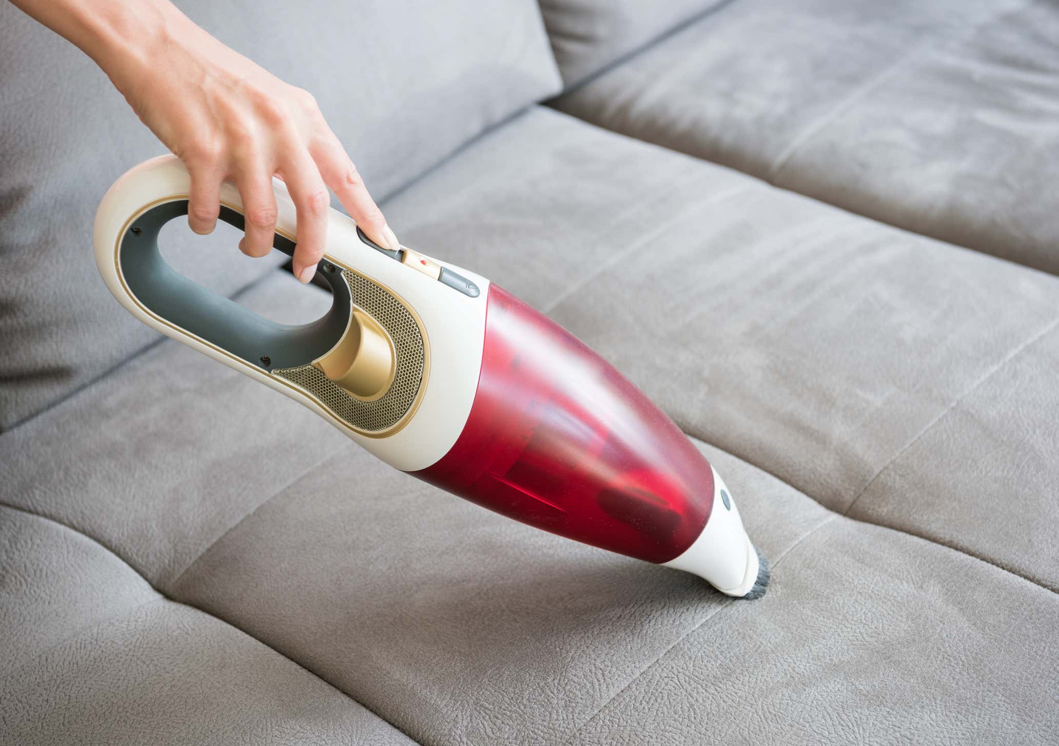 portable vacuum being used on a car seat 便携式吸尘器被用在汽车座椅上