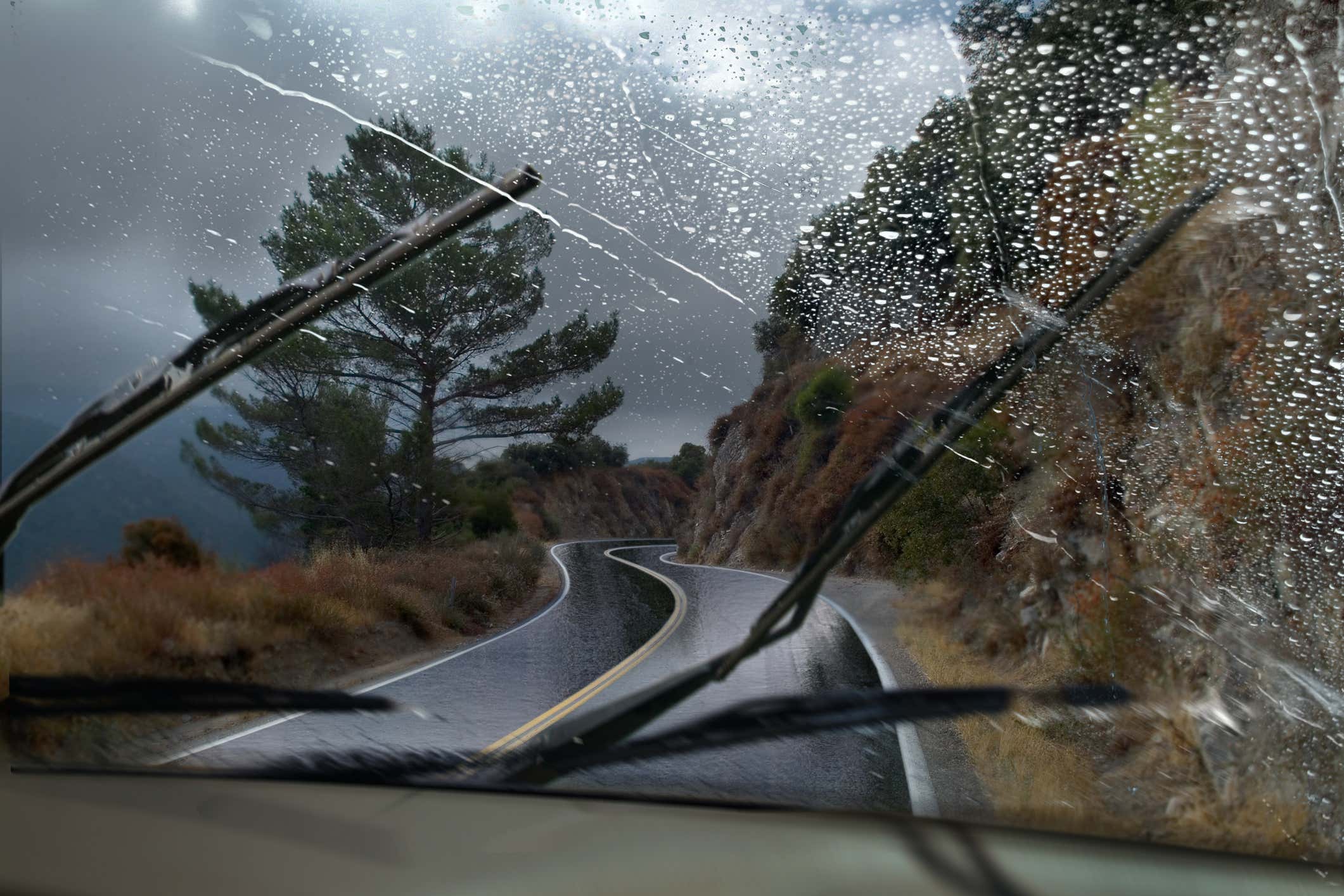 Windshield being cleaned by wiper blades during heavy rain and wind 挡风玻璃在大雨和风中被刮水刀片清洁
