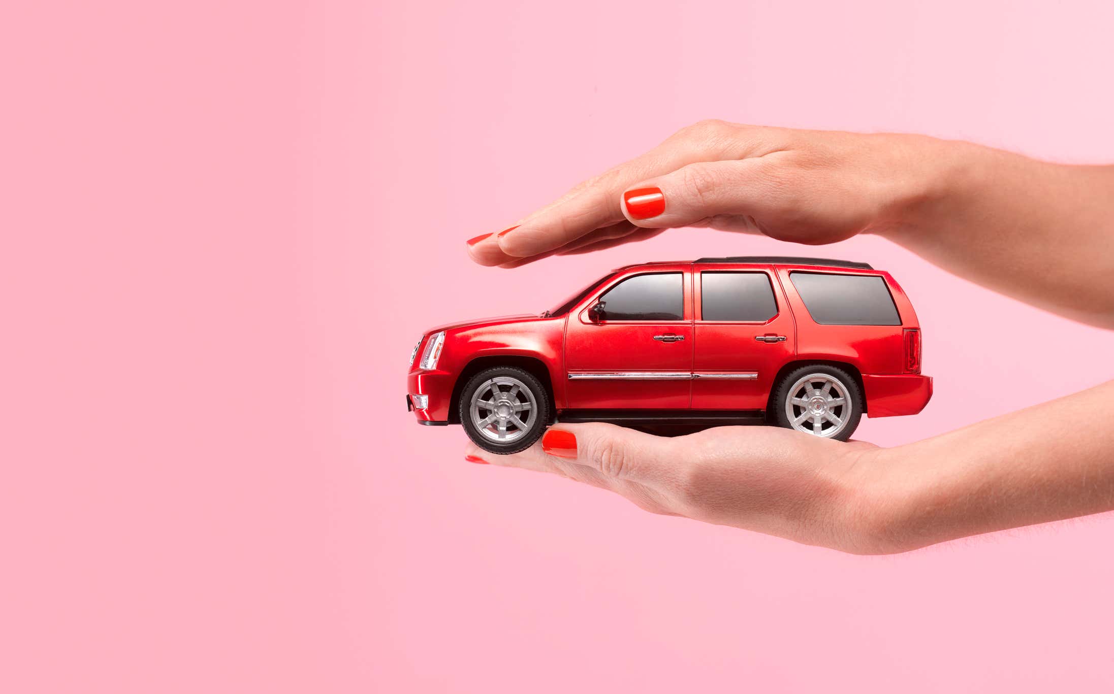 A hand holding a small car. 拿着一辆小汽车的手。