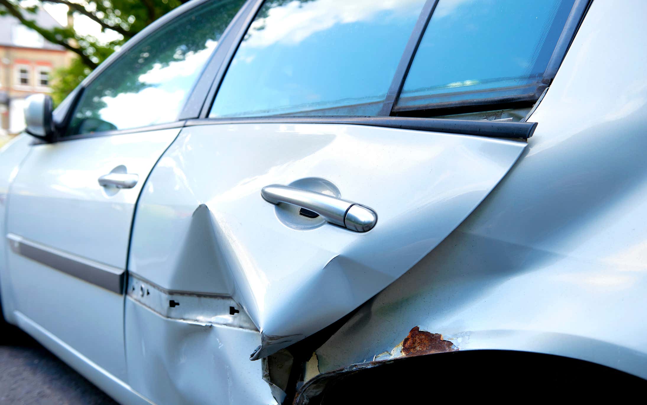 A dented car door. 有凹痕的车门。
