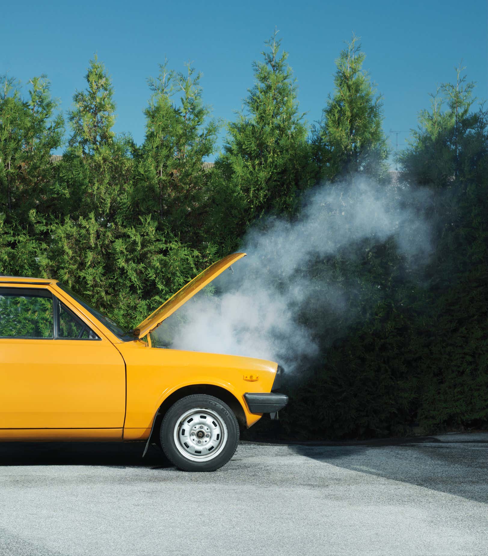 Yellow car smoking on the side of the road. 黄色汽车在路边冒烟。