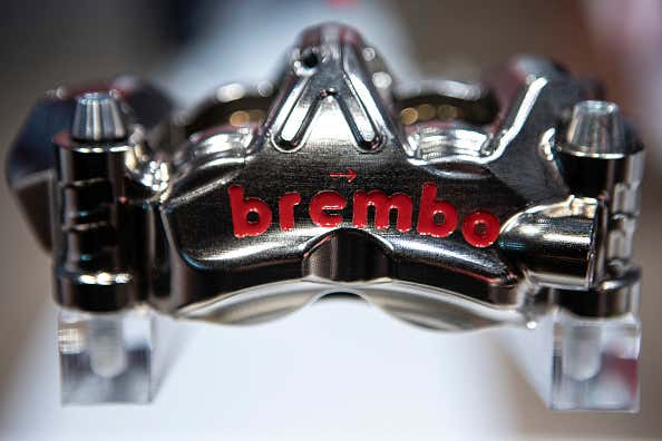 A close-up of a silver Brembo brake caliper. 银色brembo制动轮尺的特写镜头。