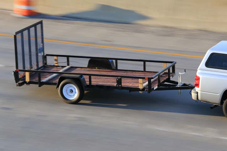 A car pulling a trailer on a highway. 在高速公路上拖着拖车的汽车。