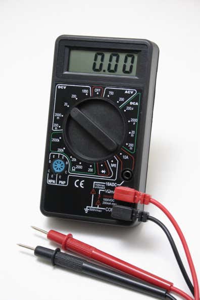 A black automotive multimeter with black and red leads. 黑色的汽车万用表,有黑色和红色的引线。