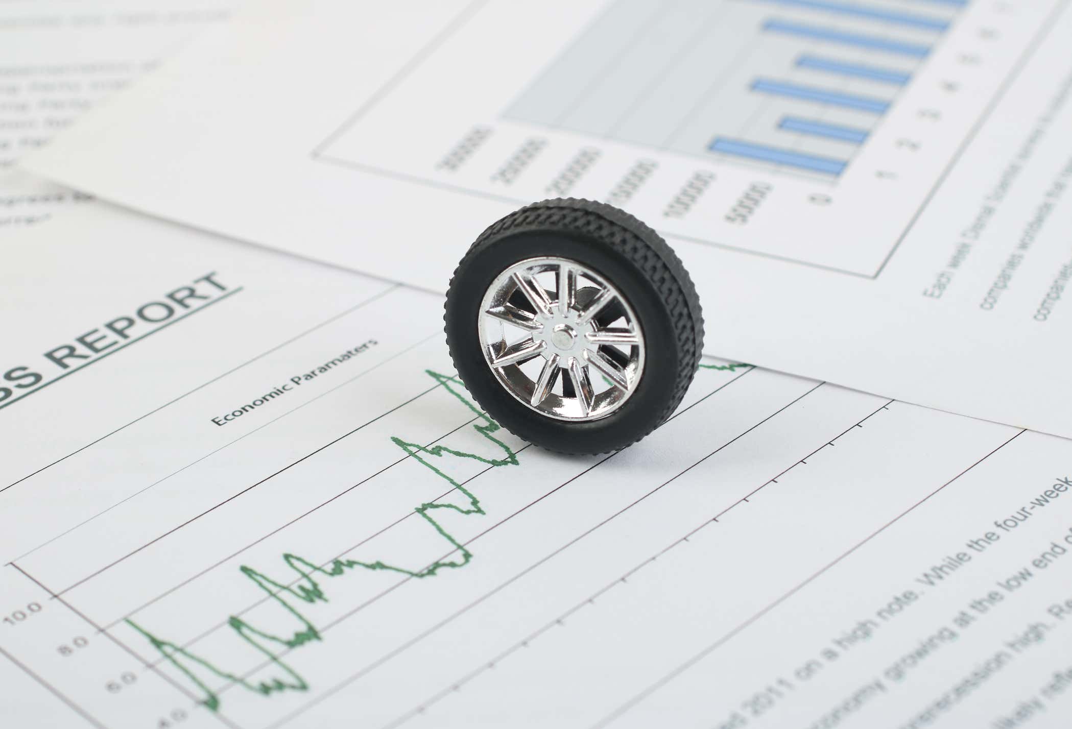 A toy tire sitting on a pile of papers. 一个玩具轮胎坐堆纸。