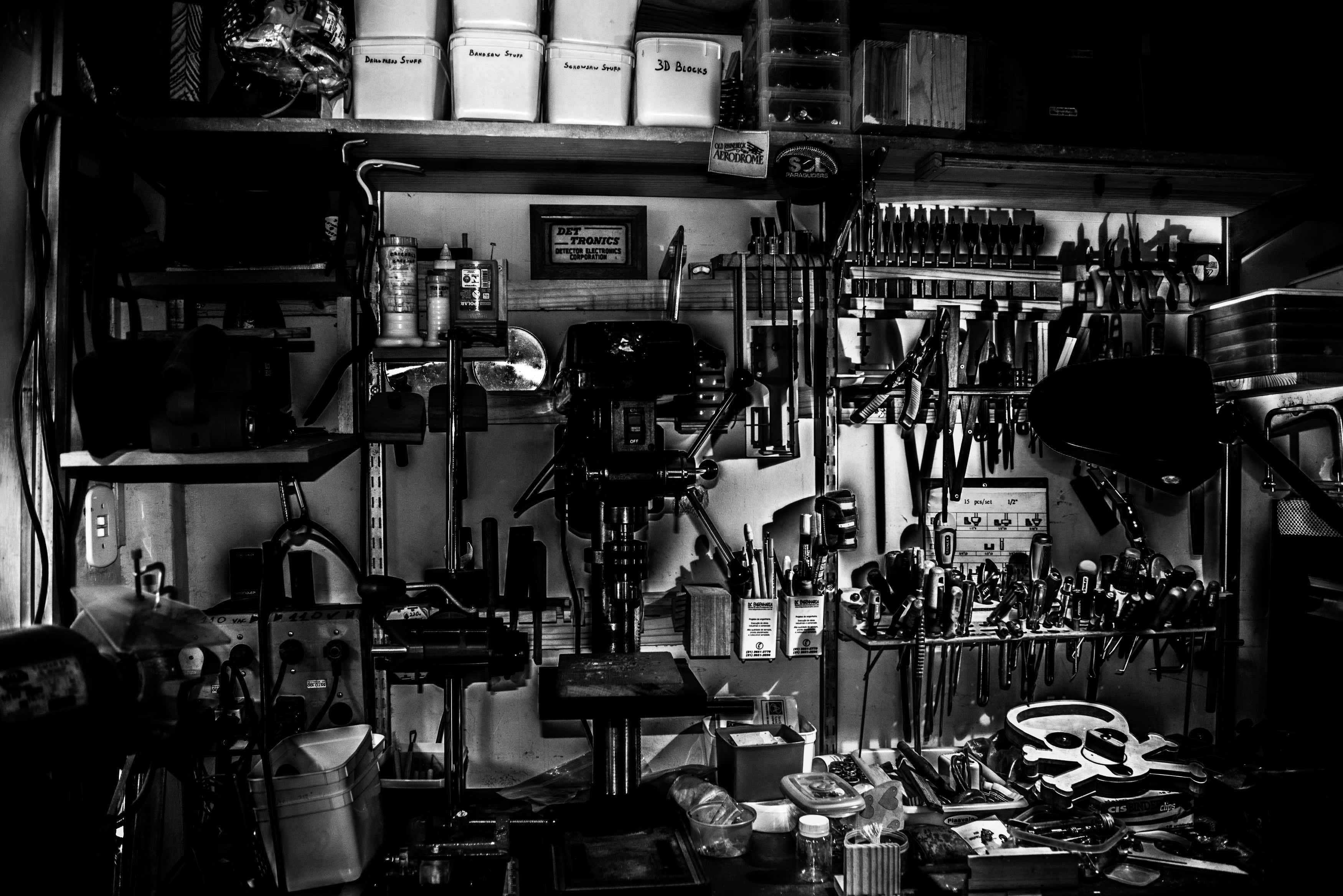 A black and white image showing garage shelving with a variety of tools. 一个黑色和白色的图像显示车库的架子与各种工具。