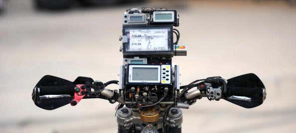 A GPS unit sits atop the gauge cluster of a motorcycle. GPS单元位于摩托车的仪表集群上。