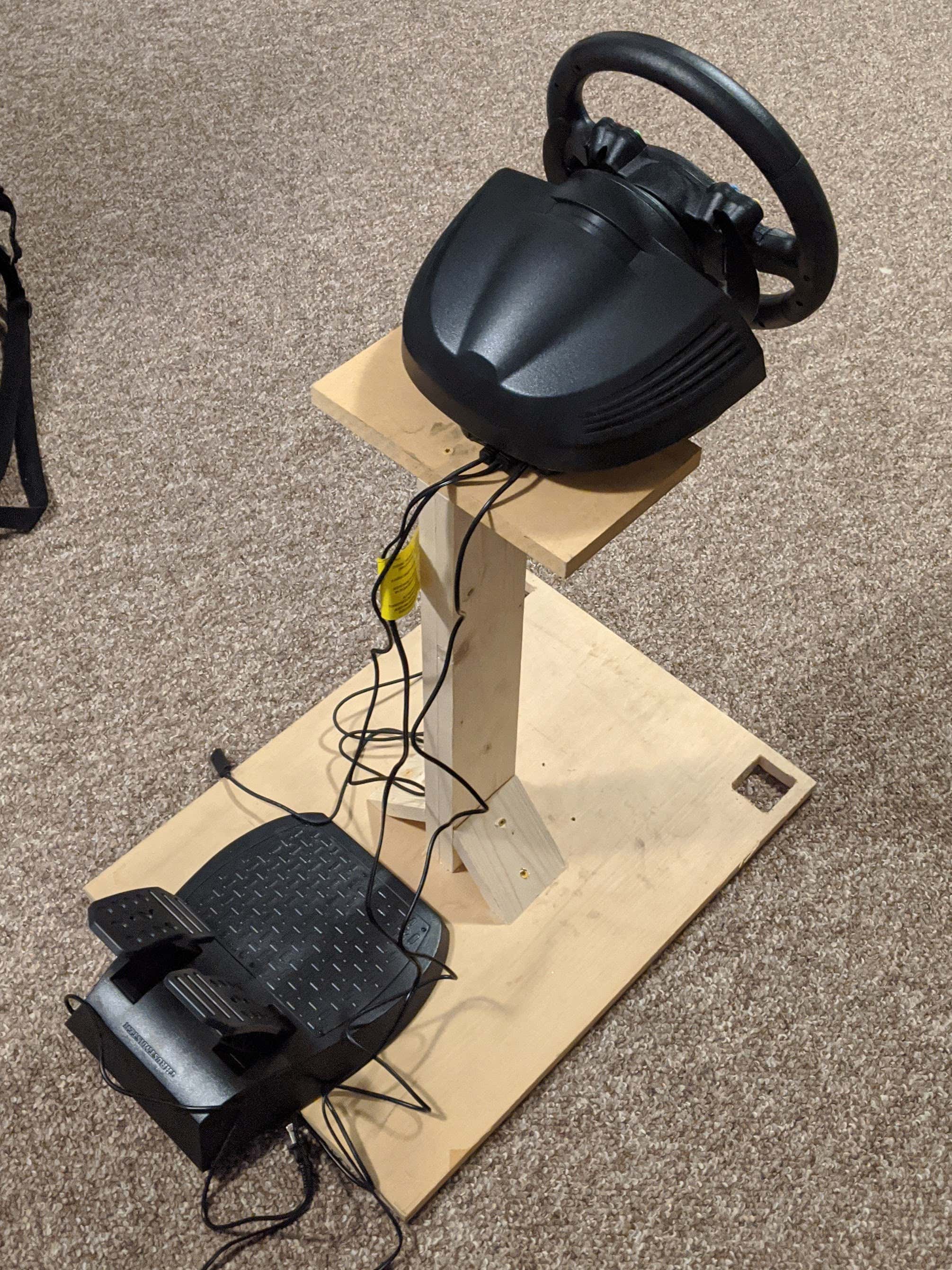 Race gaming rig with wheel and pedals on a wooden stand 木制支架上有轮子和踏板的赛车游戏装置
