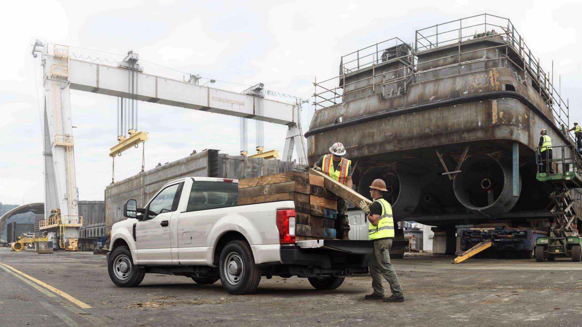 Loading timbers into back of a truck 把木材装进卡车后面