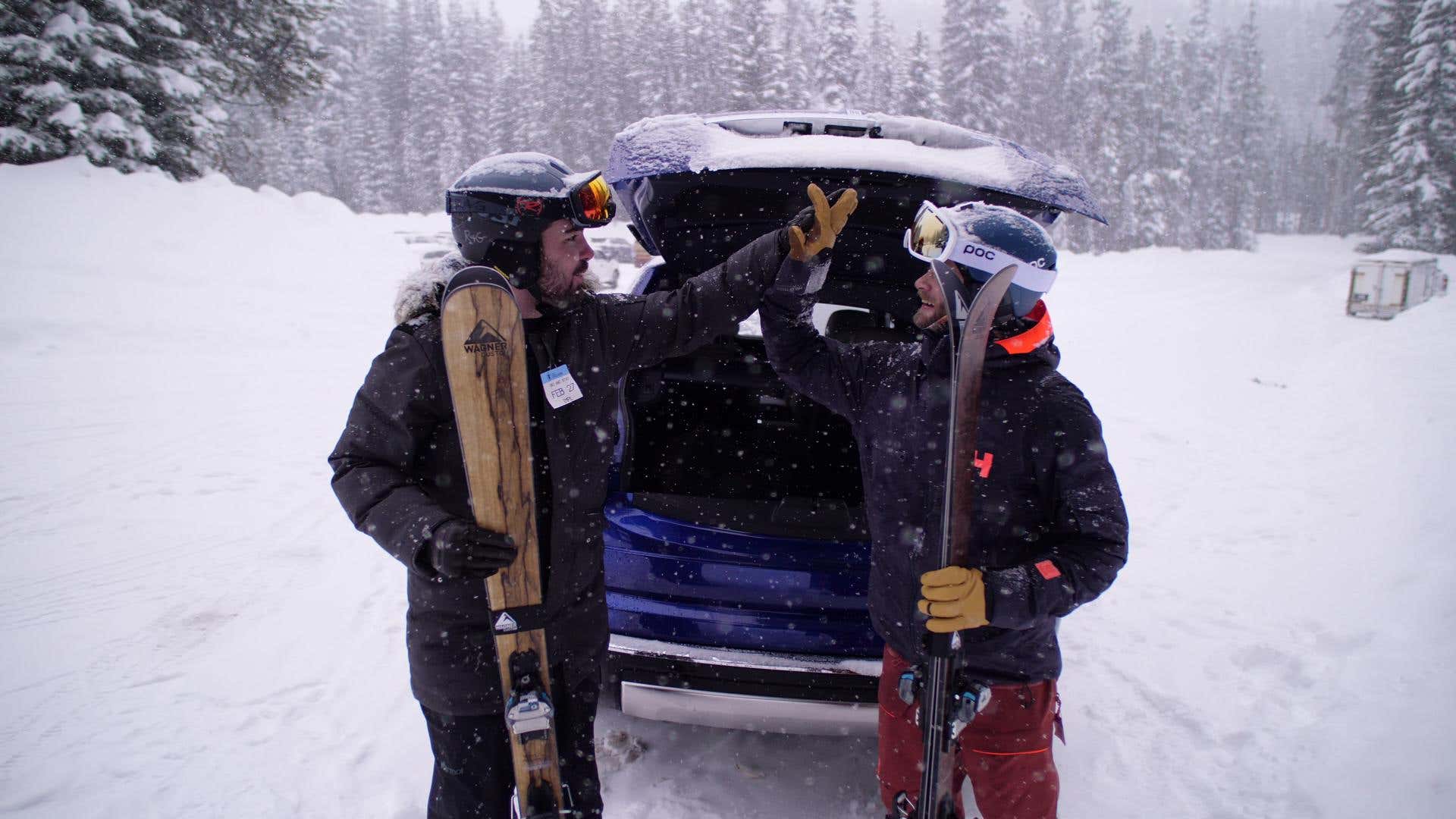 The author hi-fives his friend in front of a Rolls-Royce Cullinan SUV. 作者在滚动ryce cullinan suv前面的女朋友。