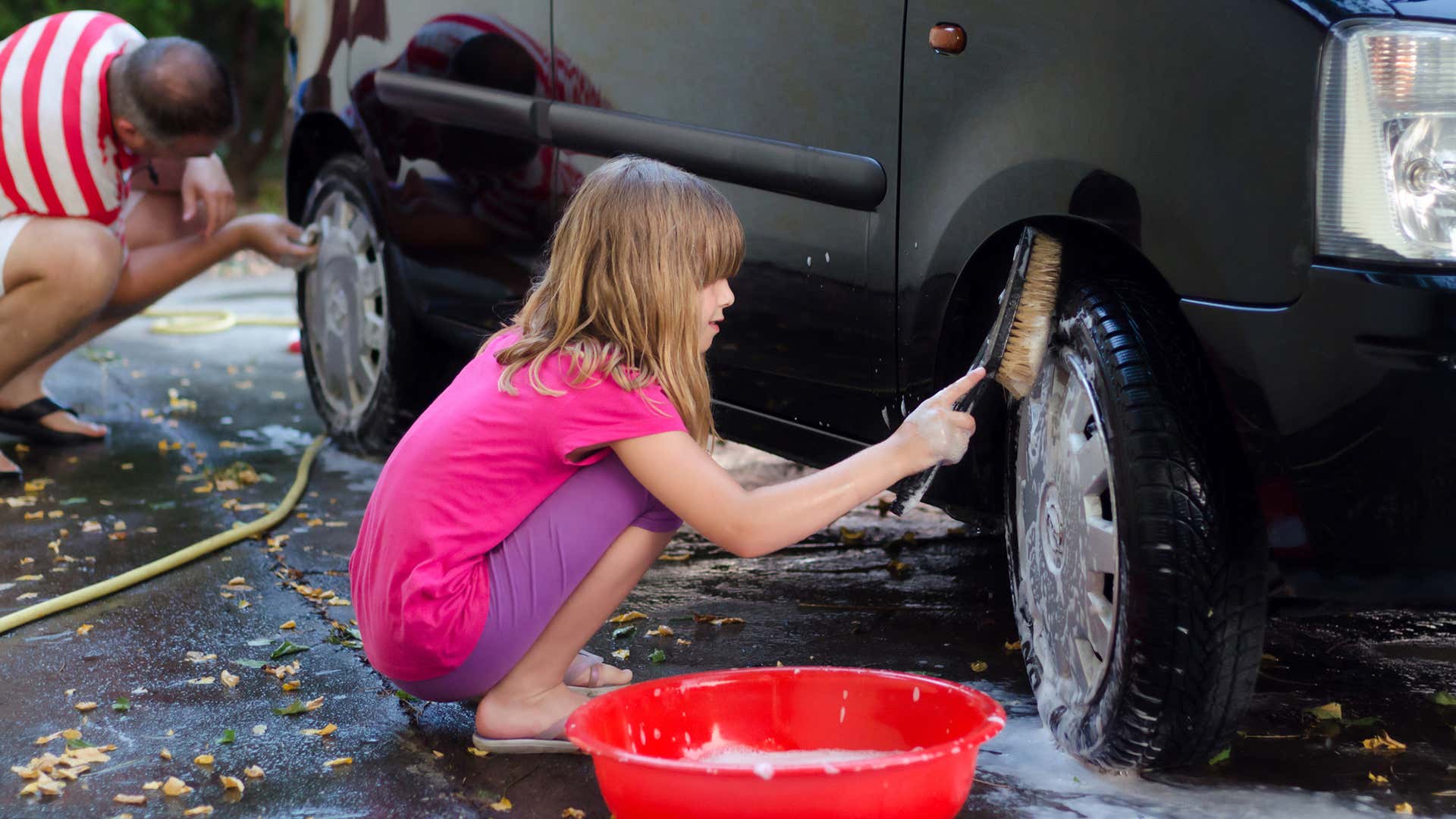 Use a hard-bristle brush to wash a car's tires. 使用硬毛刷洗车轮胎。