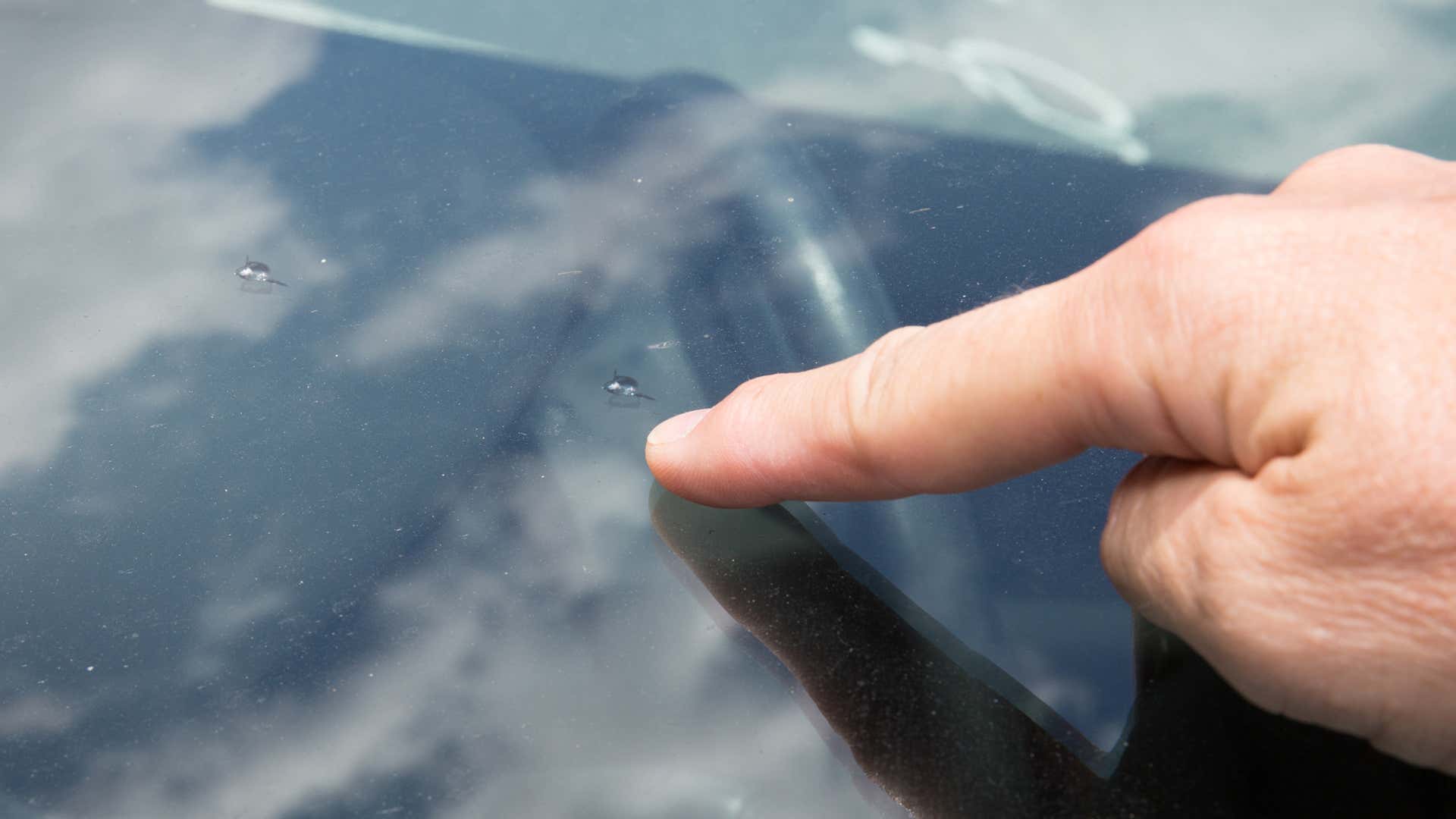 Two Rock Chips on a Windshield. 挡风玻璃上有两块岩石碎片。