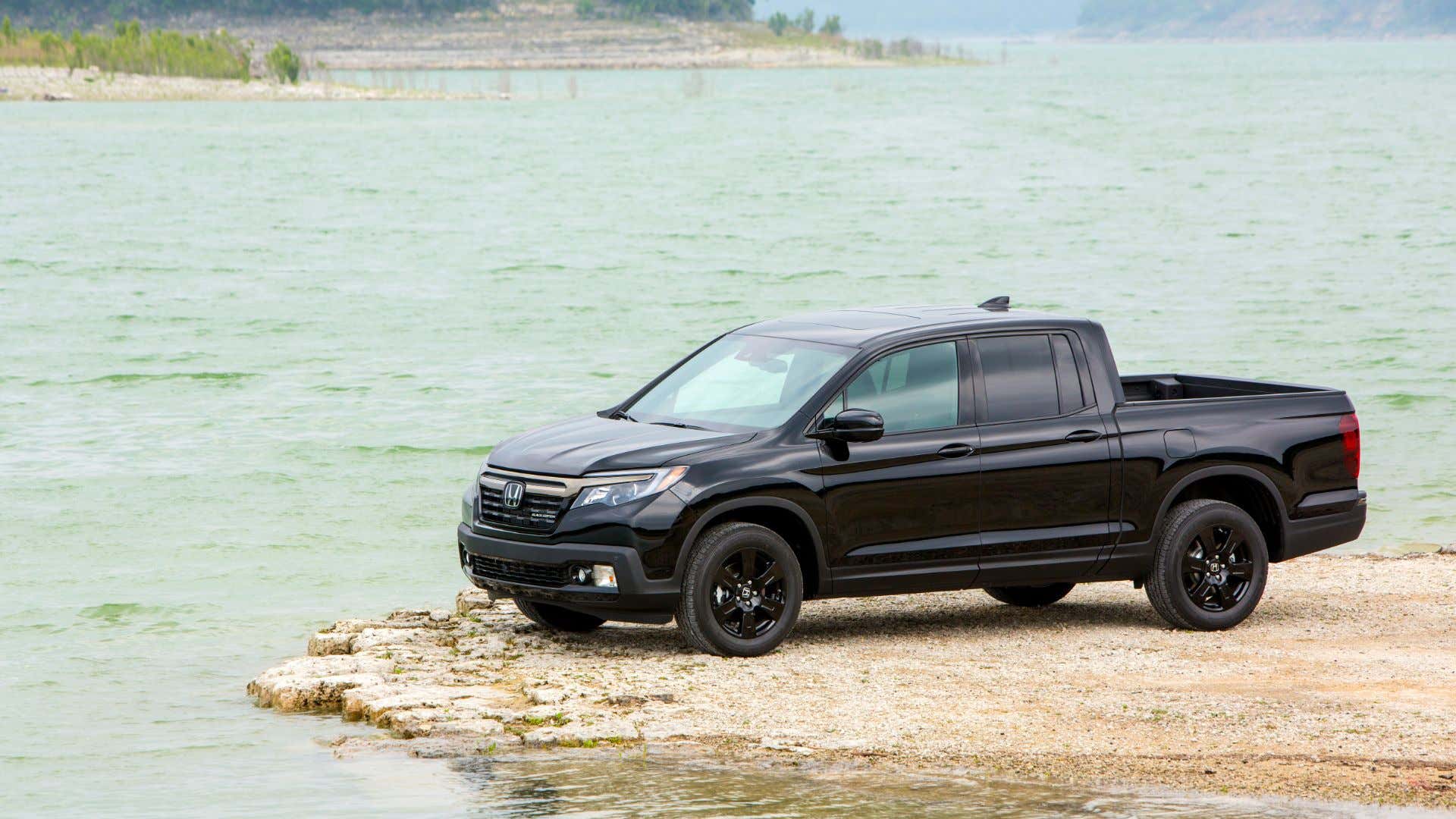 A 2020 Honda Ridgeline parked near a lake. 一辆2020年产的本田Ridgeline停在湖边。
