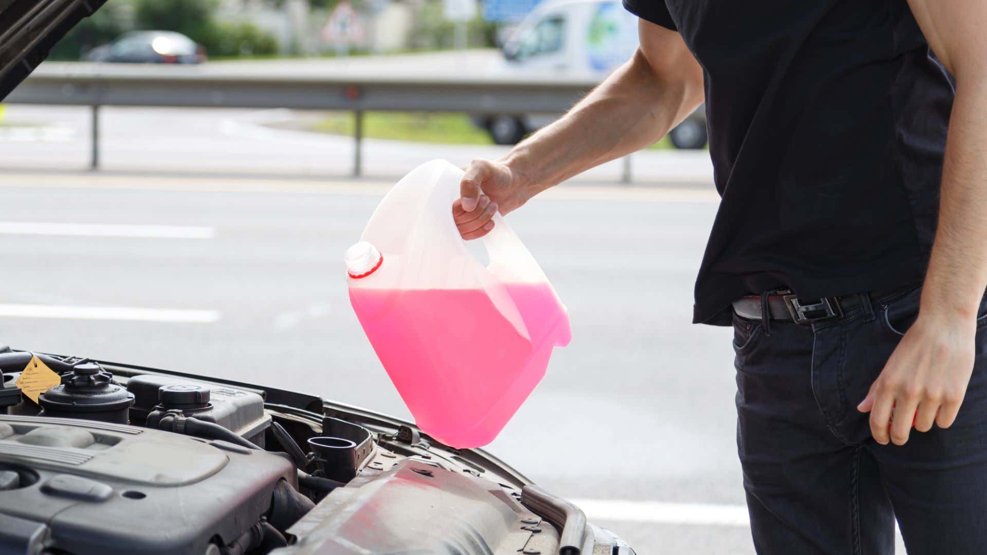 A man filling antifreeze. 一个人在填防冻剂。