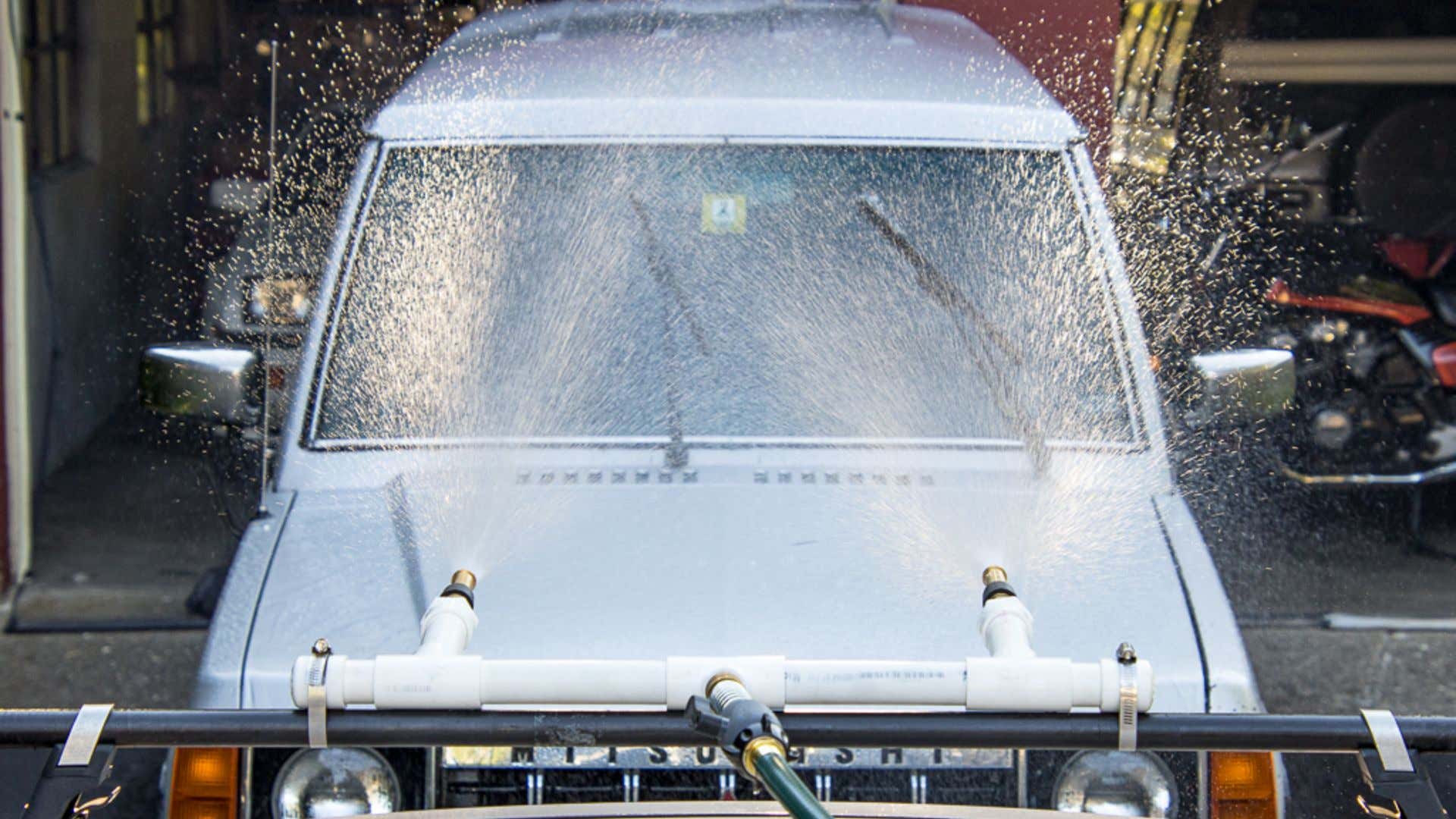 The rig spraying water at the Mitsubishi. 在三菱车上喷水的钻机。