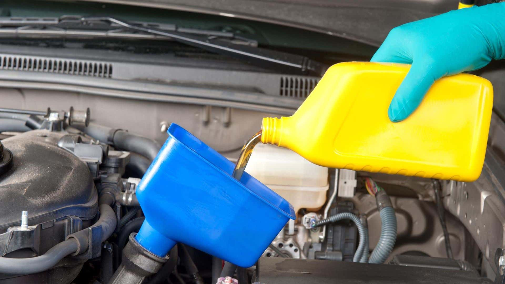 Motor oil being poured into an engine. 把机油倒进发动机里。
