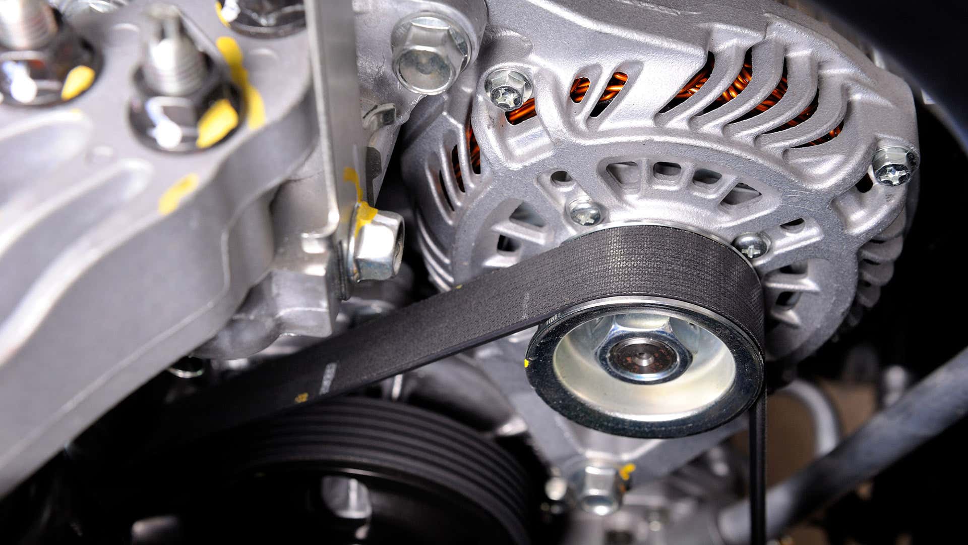 A serpentine belt wraps around the alternator pulley. 蛇纹石带缠绕在交流发电机上。