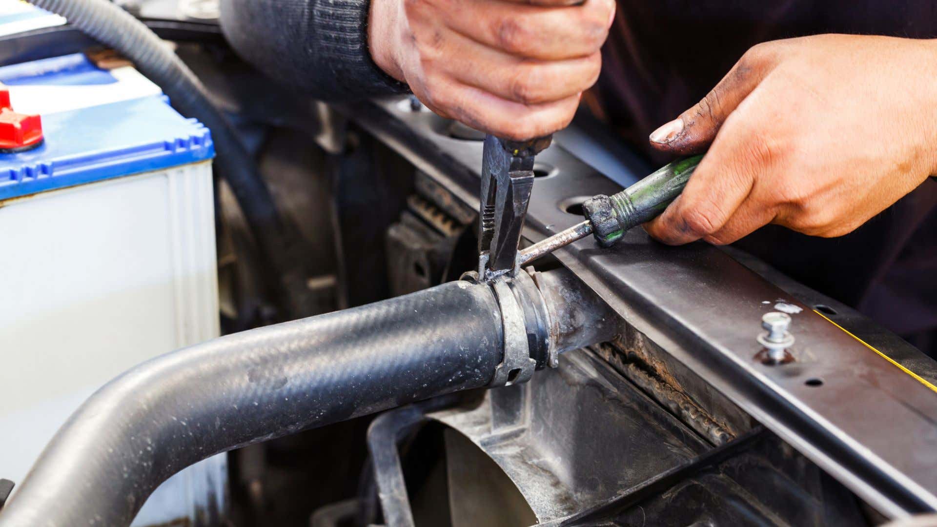 Pulling apart a radiator hose. 正在拆散热器软管。