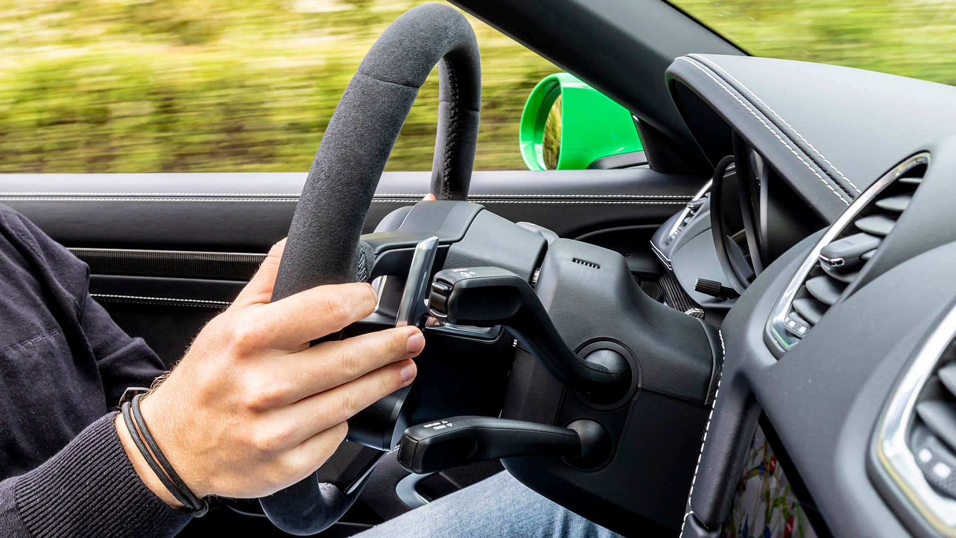 A driver uses the right-hand paddle shifter in a Porsche 911. 在一辆保时捷911里,一名司机正在用右手换档。