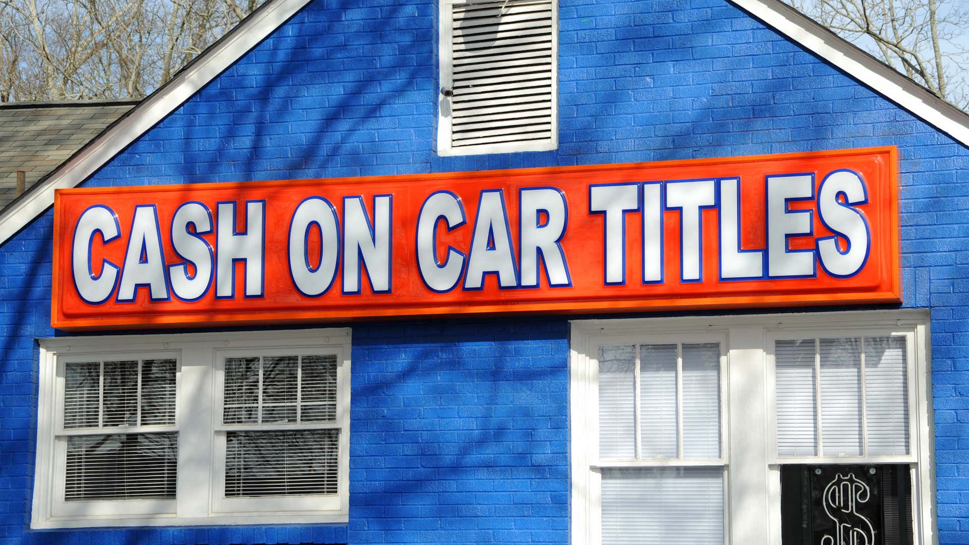 A business posts a sign offering cash on car titles. 一家企业张贴了一个告示,说汽车所有权可以付现。