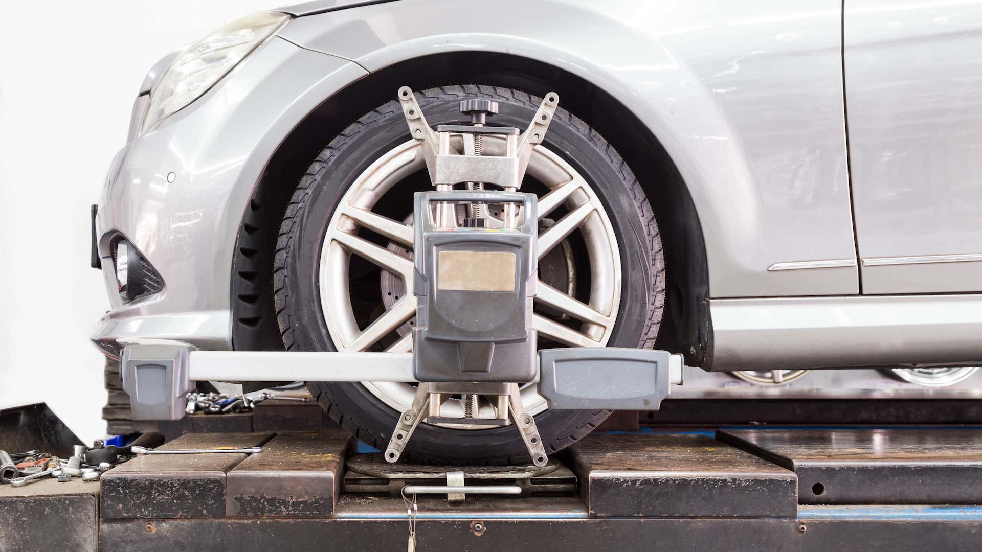 A wheel alignment tool is attached to the front driver's side tire of the car. 一个车轮对准工具是附加到前驾驶员的侧轮胎的汽车。