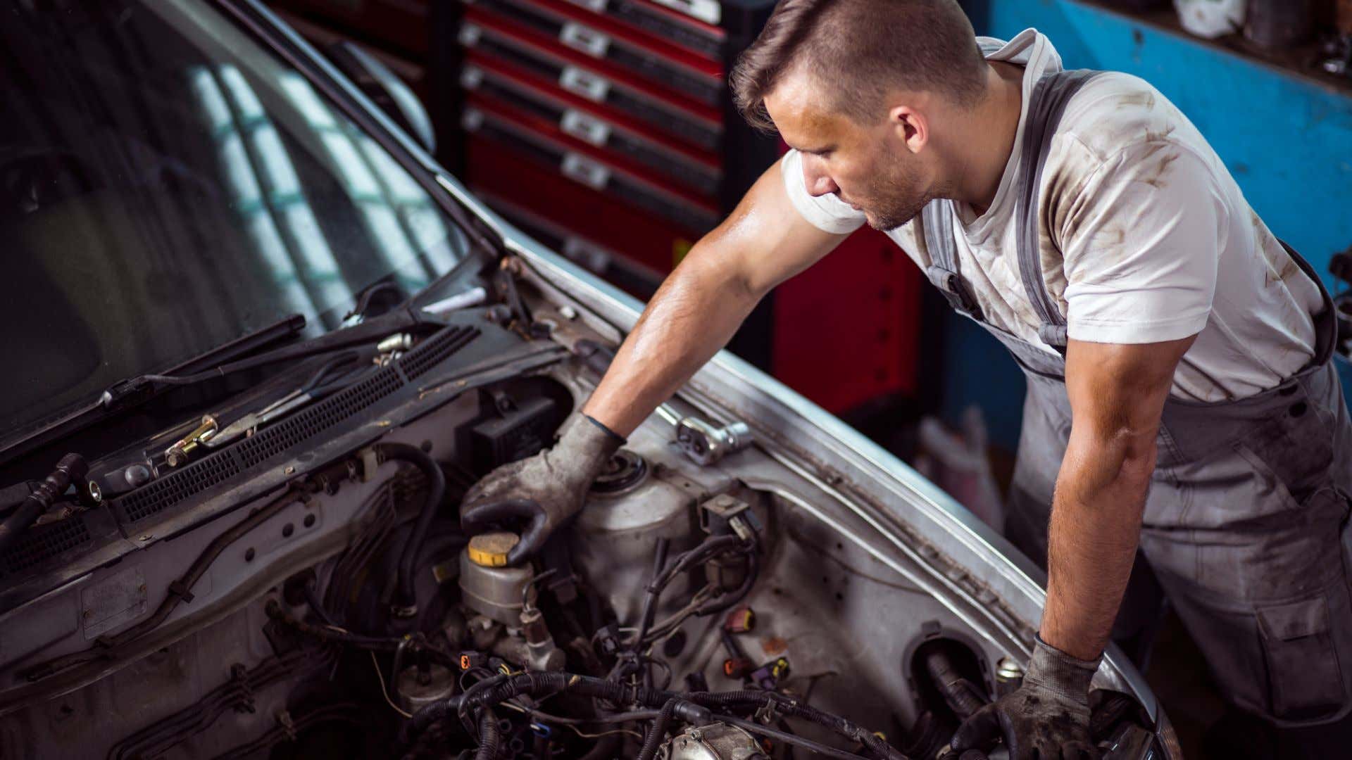 A mechanic checking the brake fluid level. 检查制动液水平的机械师。