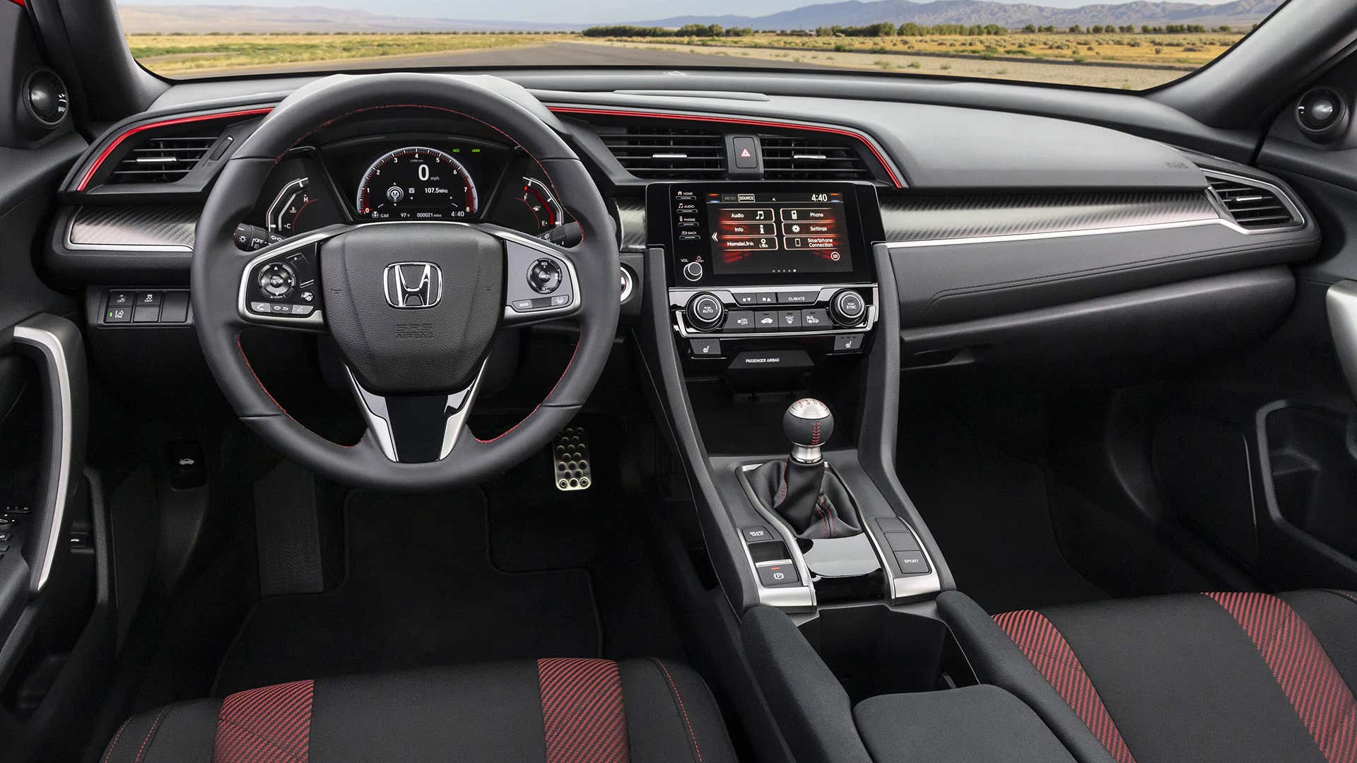 The interior of a Honda Civic Coupe Si features a stick shift and red and black seats. 本田思域轿跑车的内部具有棍子换档和红色和黑色座椅。