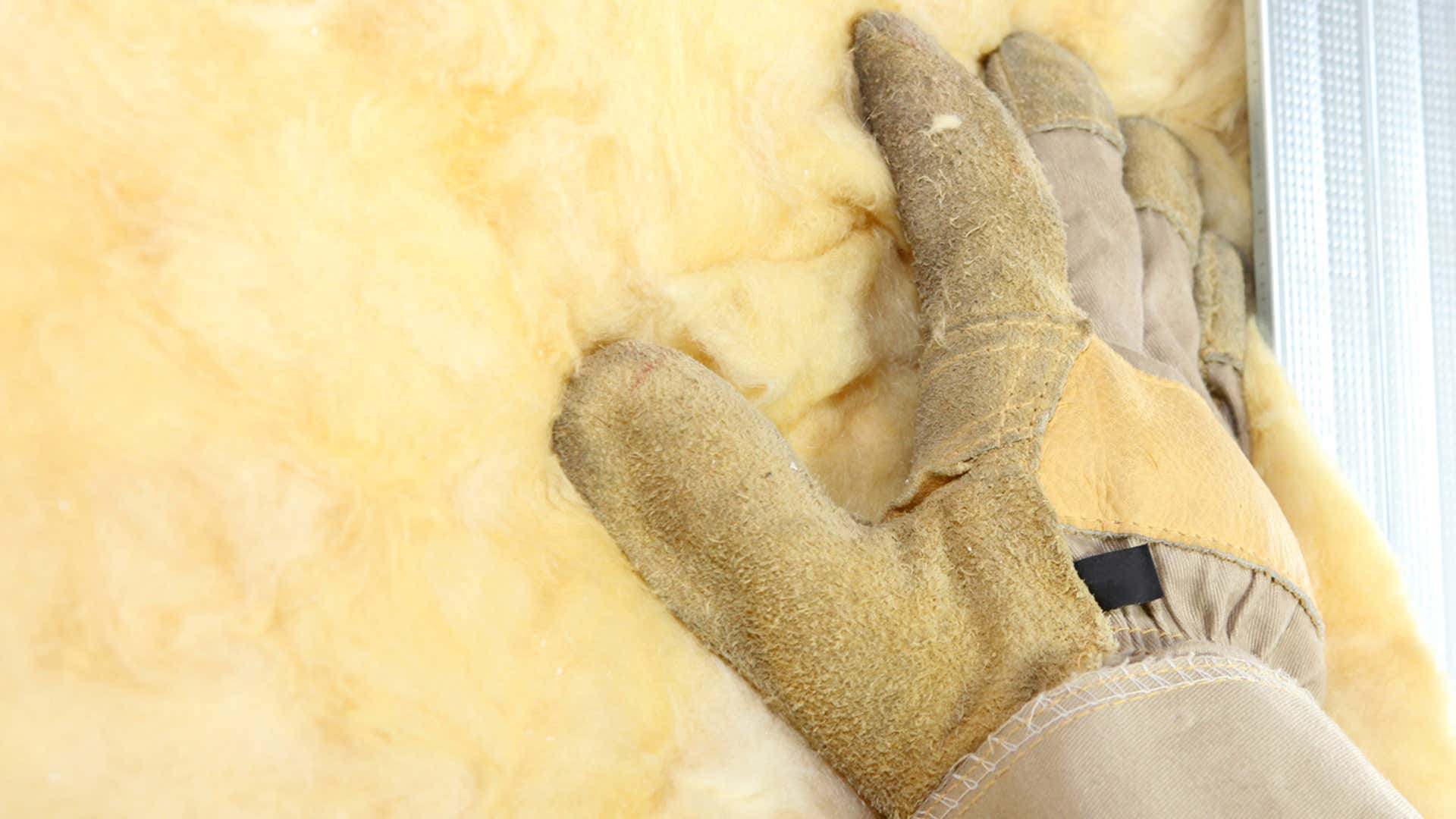 A sturdy work glove pats down insulation. 一只结实的工作手套可以轻拍绝缘层。