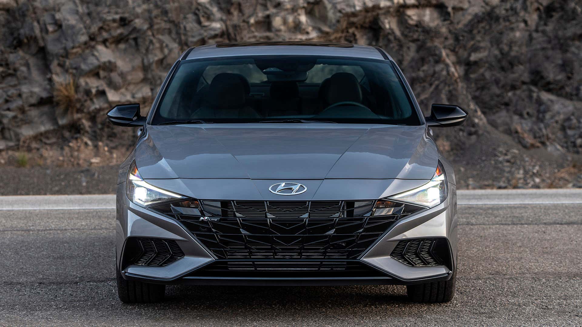 A gray Hyundai Elantra sits on a canyon road facing the camera. 灰色现代elantra坐在峡谷路面对相机。