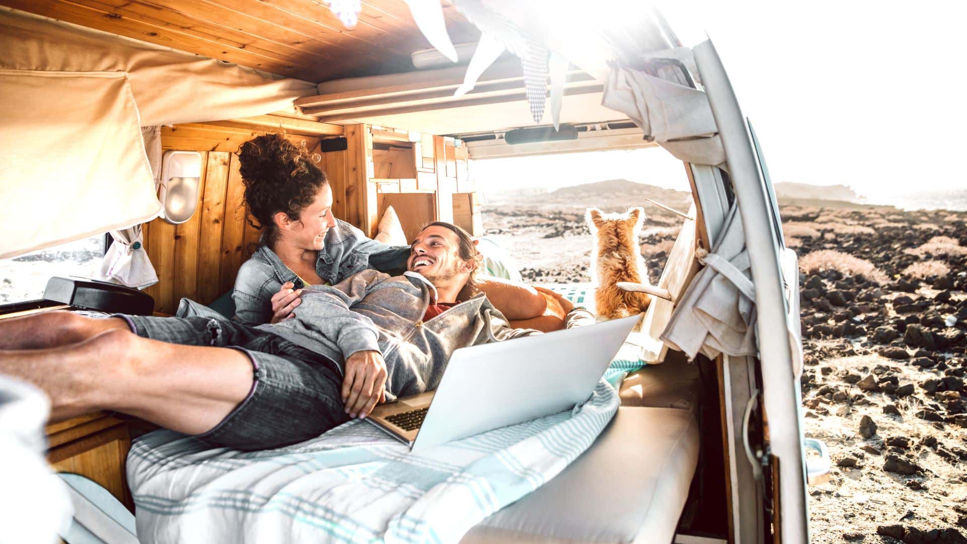 A couple lounging in their van. 一对夫妇懒洋洋地躺在他们的货车里。
