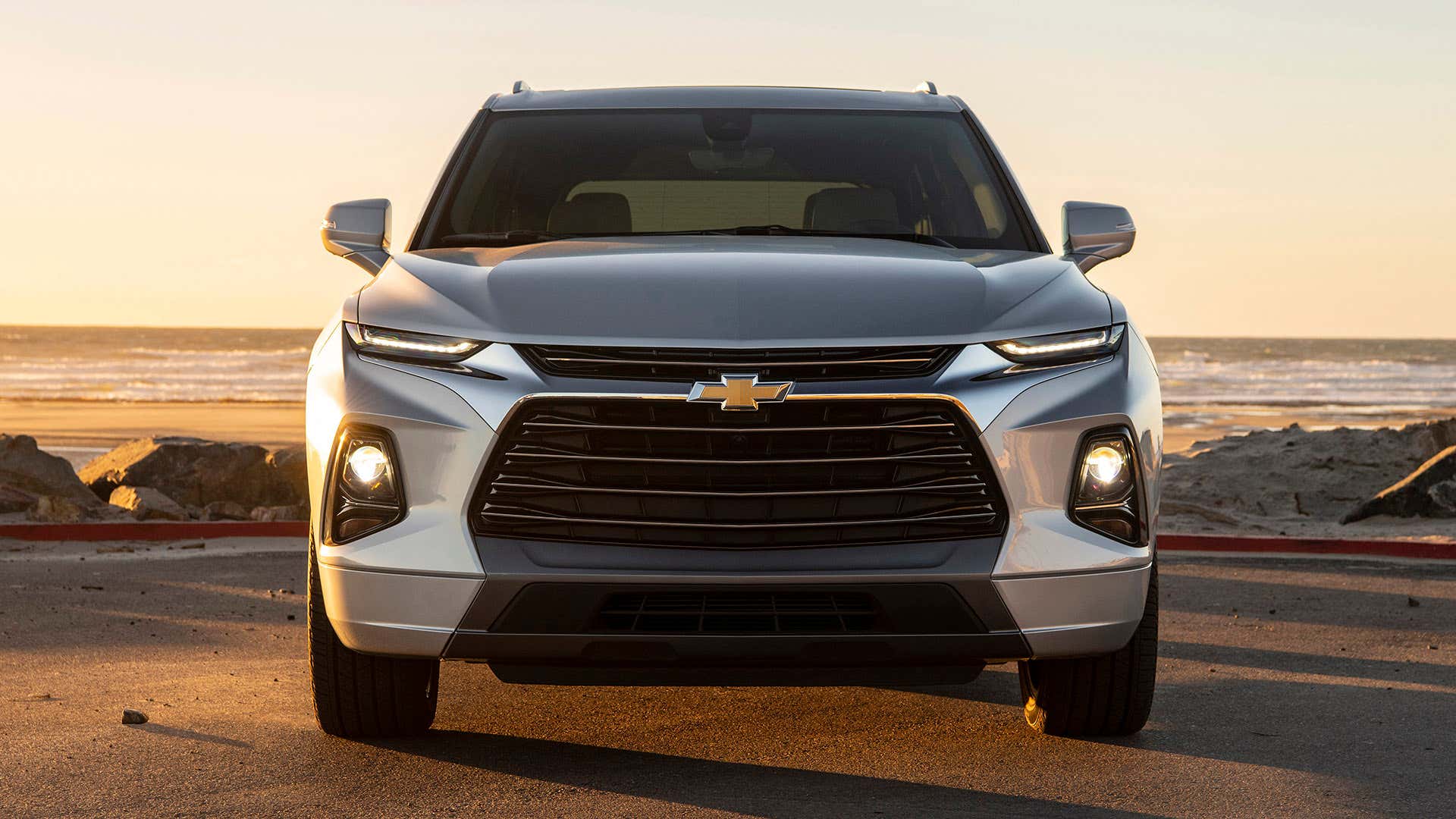 A silver 2019 Chevrolet Blazer shows its HID headlights at the beach. 一家银2019雪佛兰布拉泽尔在海滩上显示了它的HID前灯。