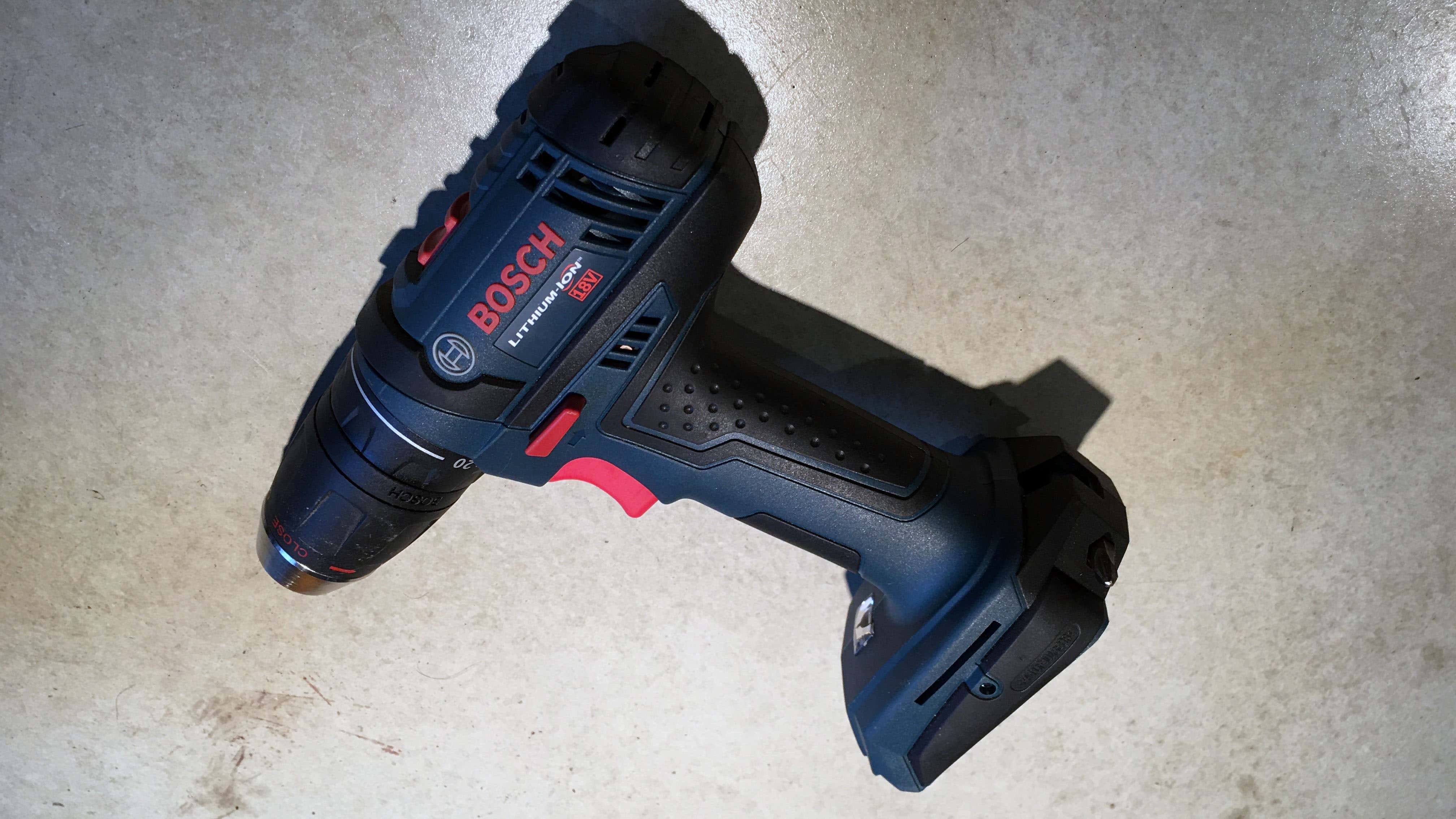 A Bosch lithium-ion cordless drill on a concrete counter. 博世锂离子无线电钻在混凝土柜台上。