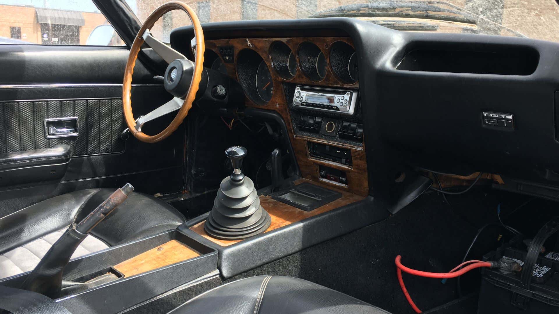 The interior of an Opel GT with wood trim and black leather. 用木材装饰和黑色皮革的欧宝GT的内部。