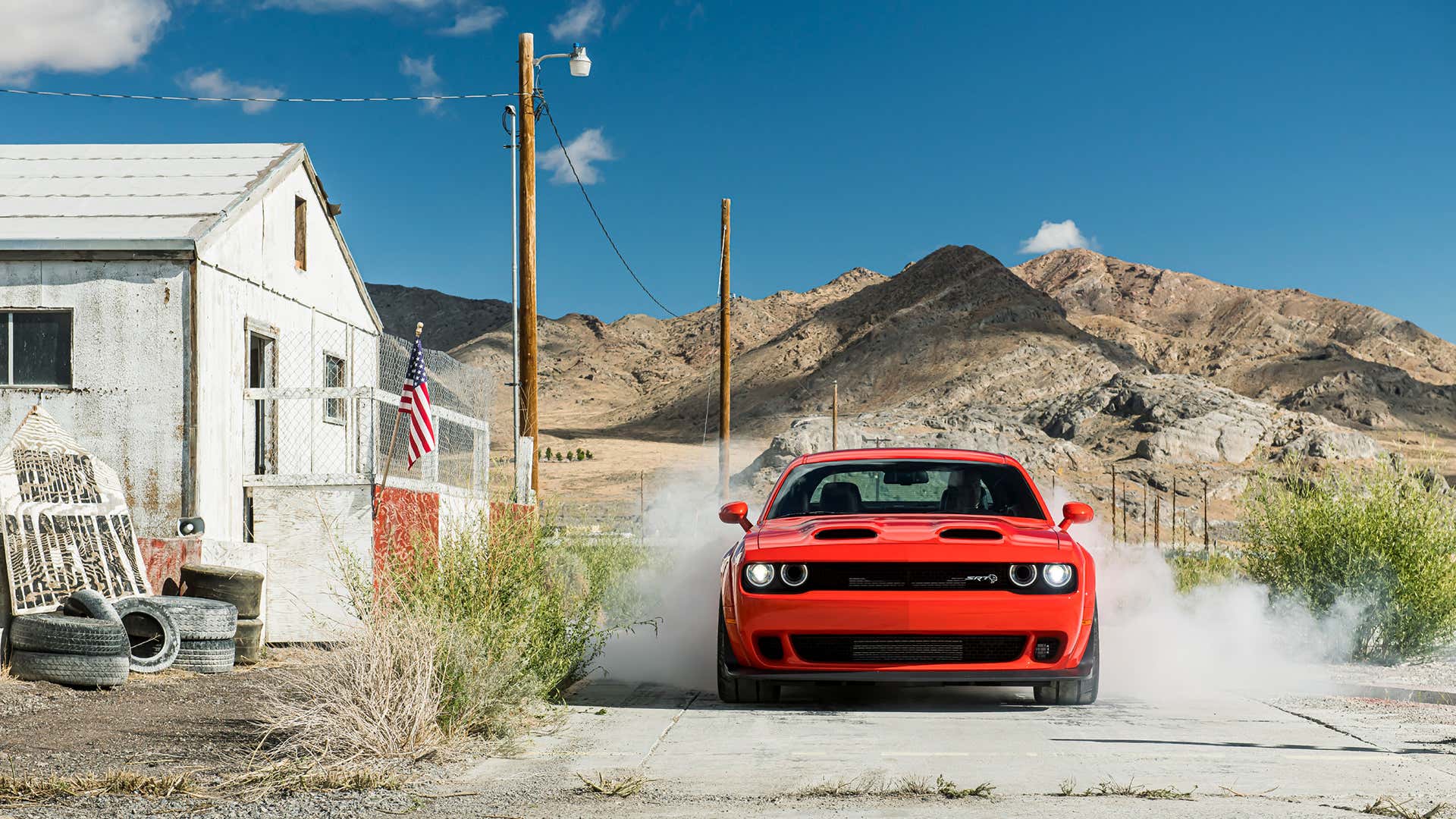 A red Dodge Challenger SRT Hellcat starts a burnout. 红色道奇挑战者SRT地狱猫开始精疲力竭。