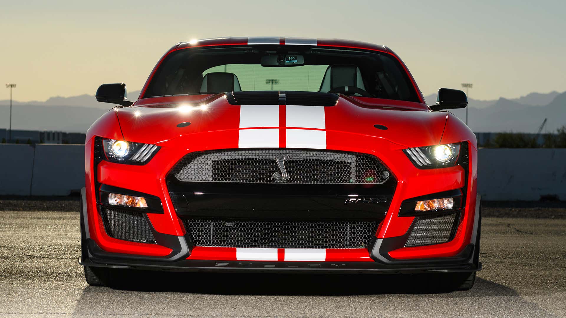 A red Ford Mustang Shelby GT500 faces the camera. 一辆红色福特野马谢尔比GT500面对着摄像机。