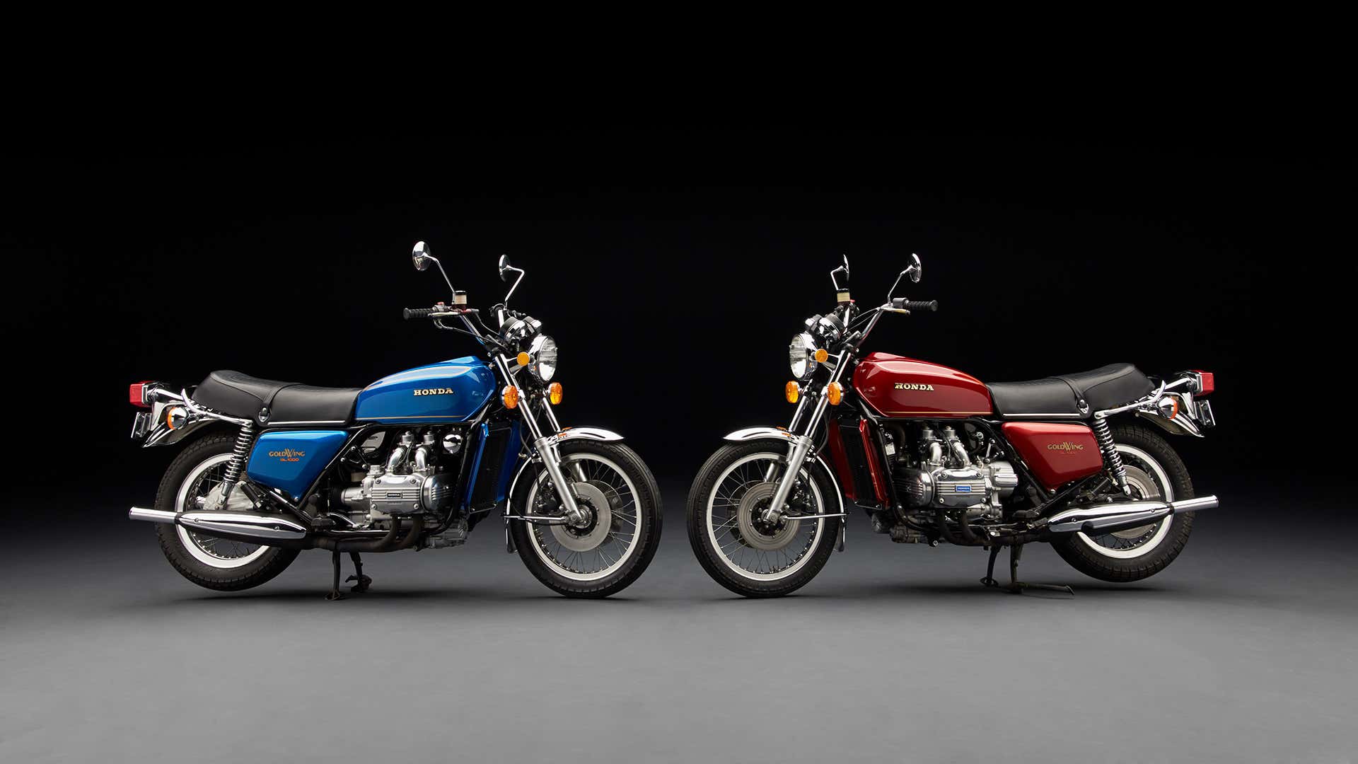 Blue and red vintage Honda Goldwings pose in a studio. 蓝色和红色葡萄酒本田Goldwings在演播室姿势。