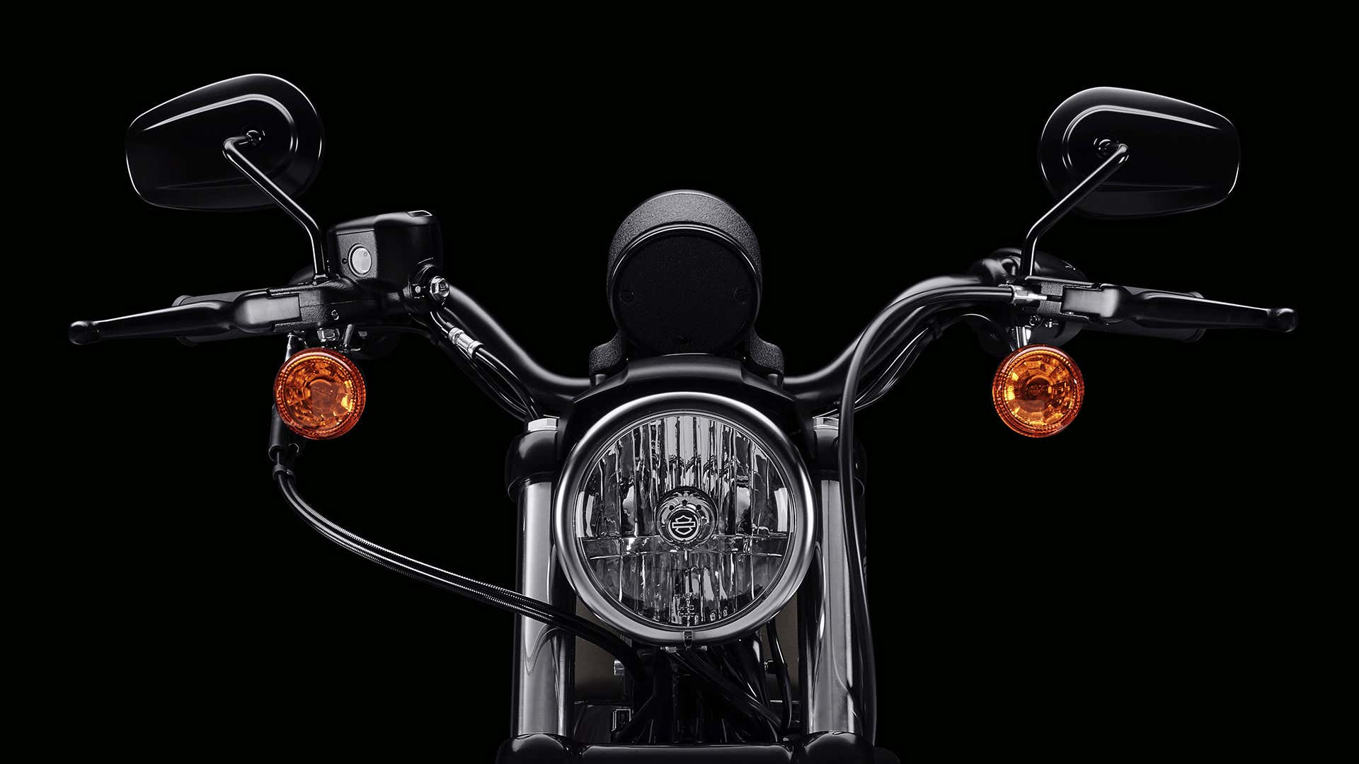 The front headlight, forks, and handlebars on a Harley-Davidson. 哈雷戴维森的前灯,叉子和把手。