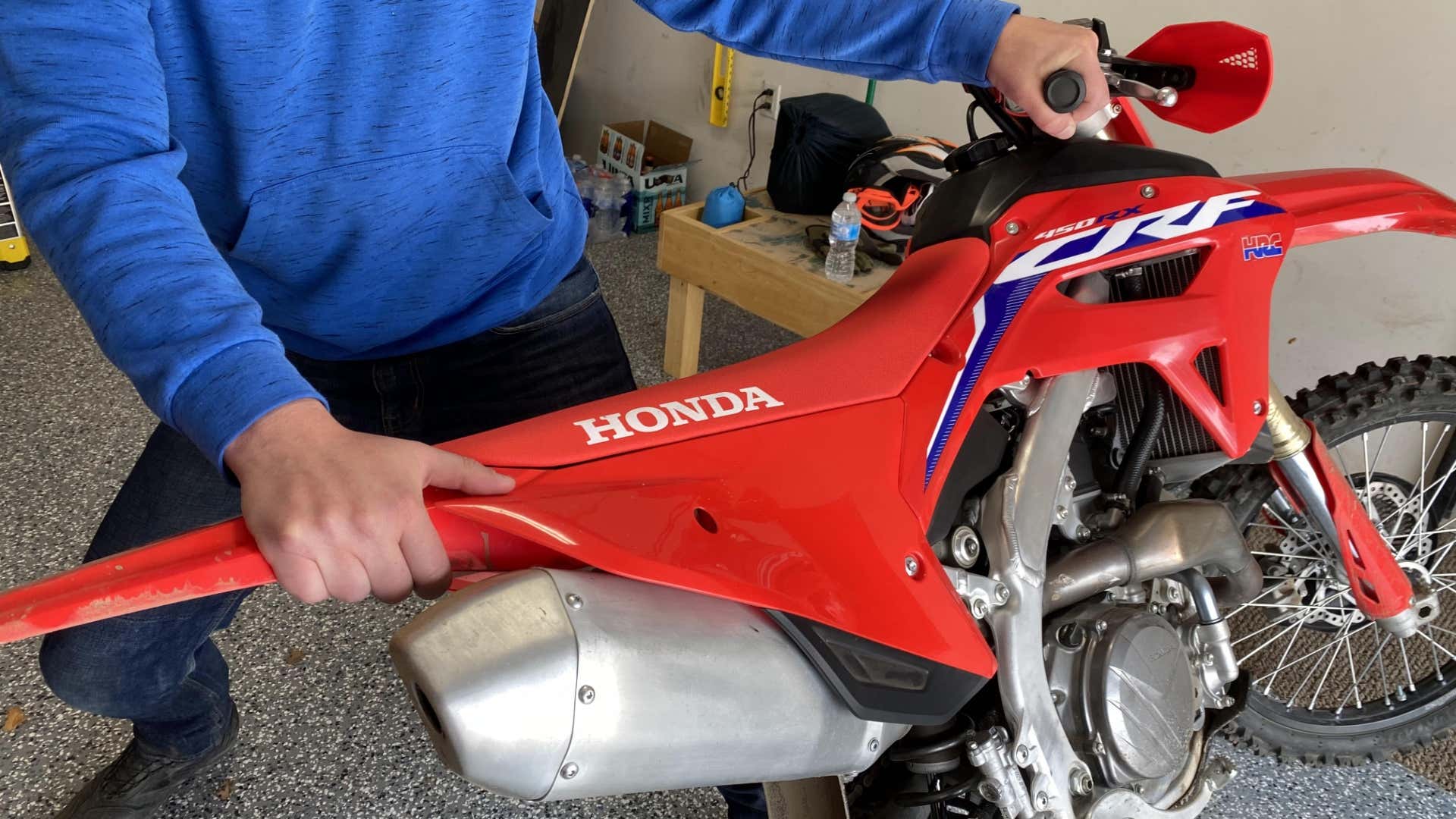 The author's hands on the handlebar and rear fender of the CRF450RX. 作者的手在车把和后挡泥板的CRF450RX。