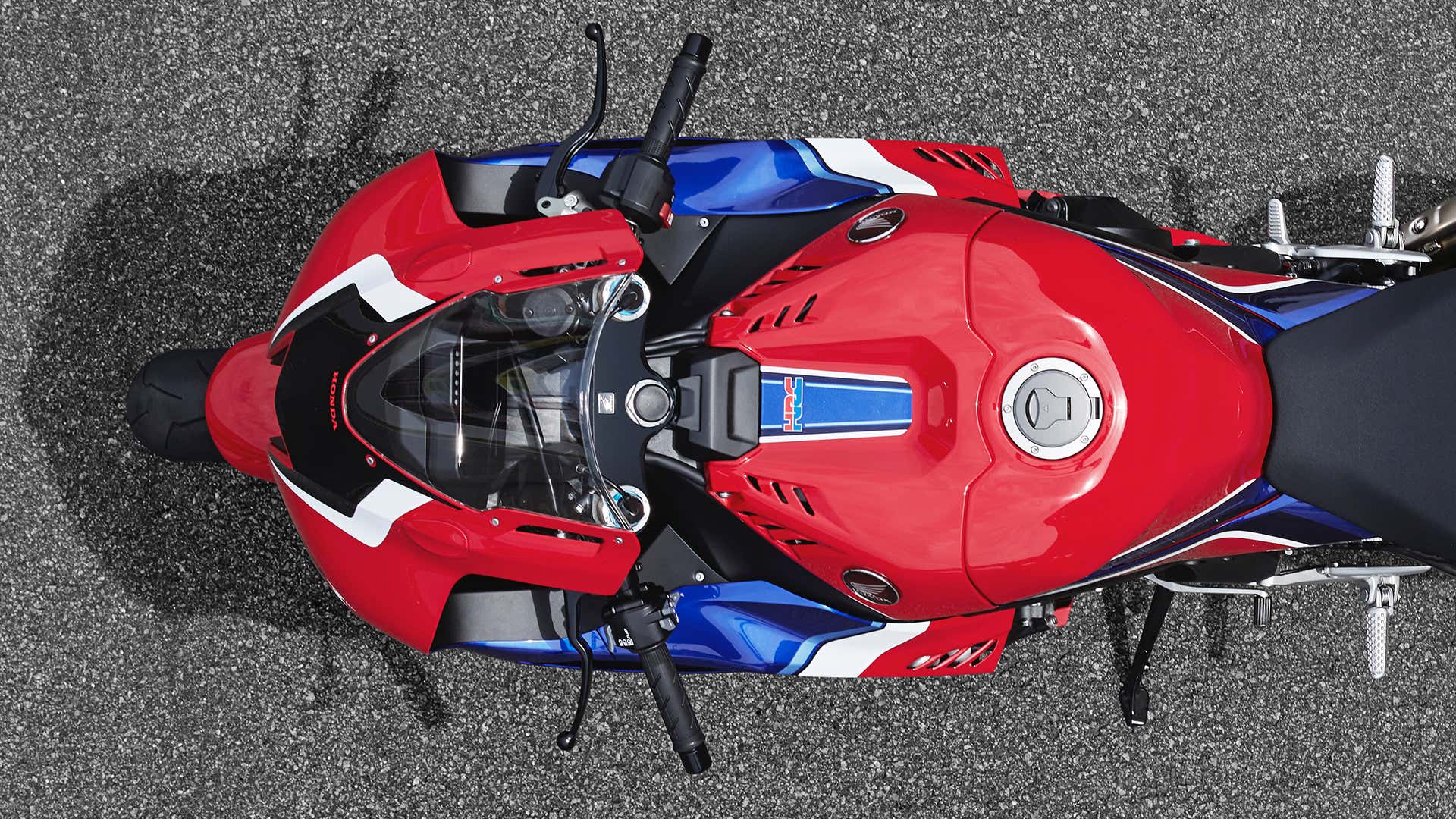An overhead view of the front end of a red, white, and blue Honda CBR sport bike. 红色,白色和蓝色本田CBR运动自行车的前端的顶部视图。