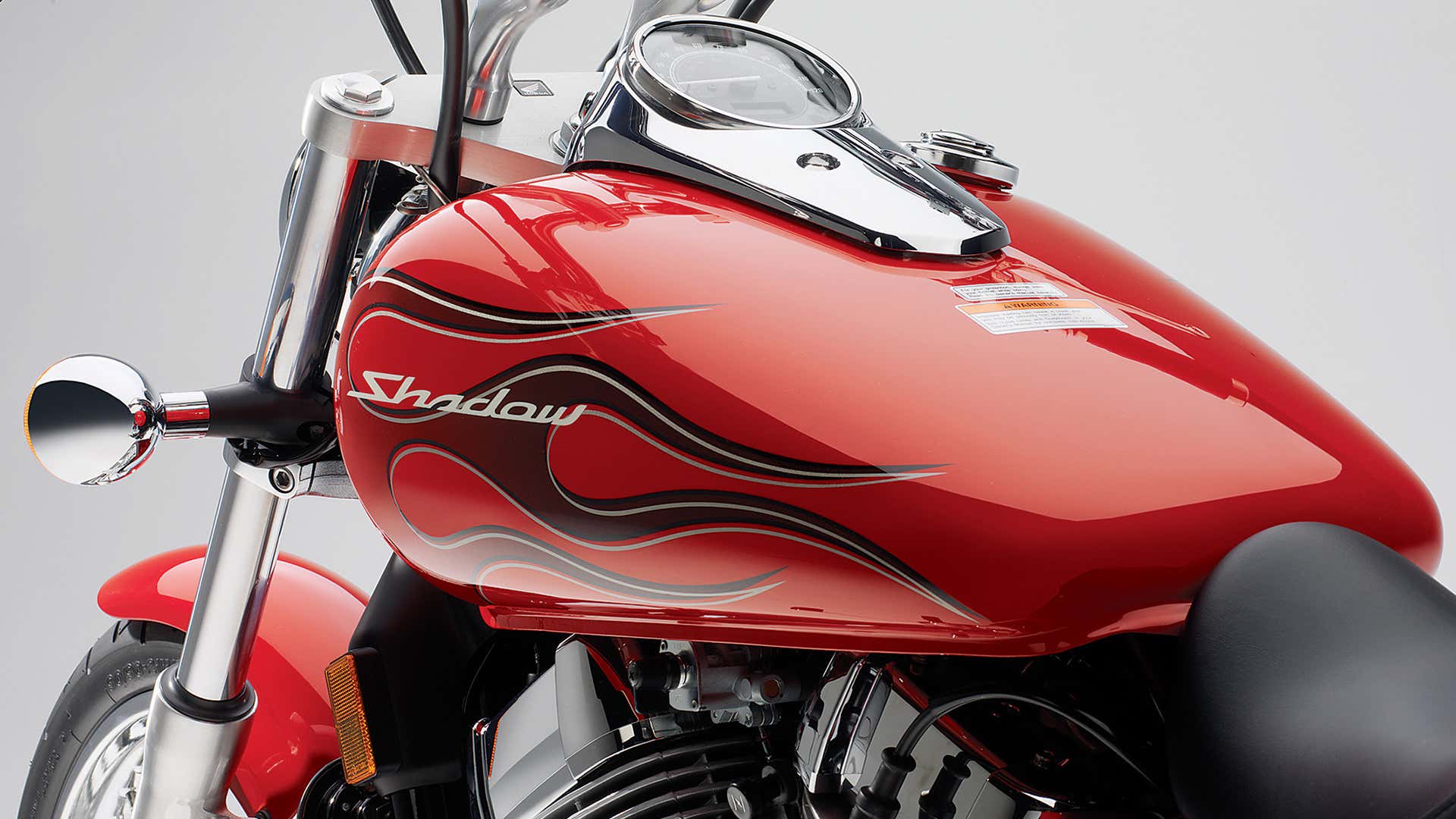 A Honda Shadow Spirit with a red gas tank with flames. 本田暗影精神与有火焰的红色气罐。