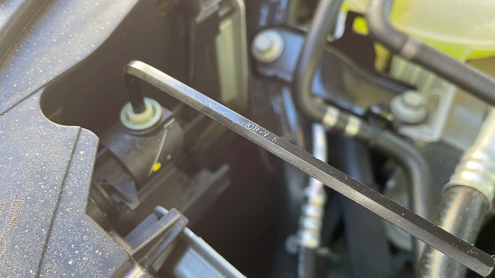 A close-up view of a hex key set adjusting headlights. 六角键集调整前灯的特写镜头视图。