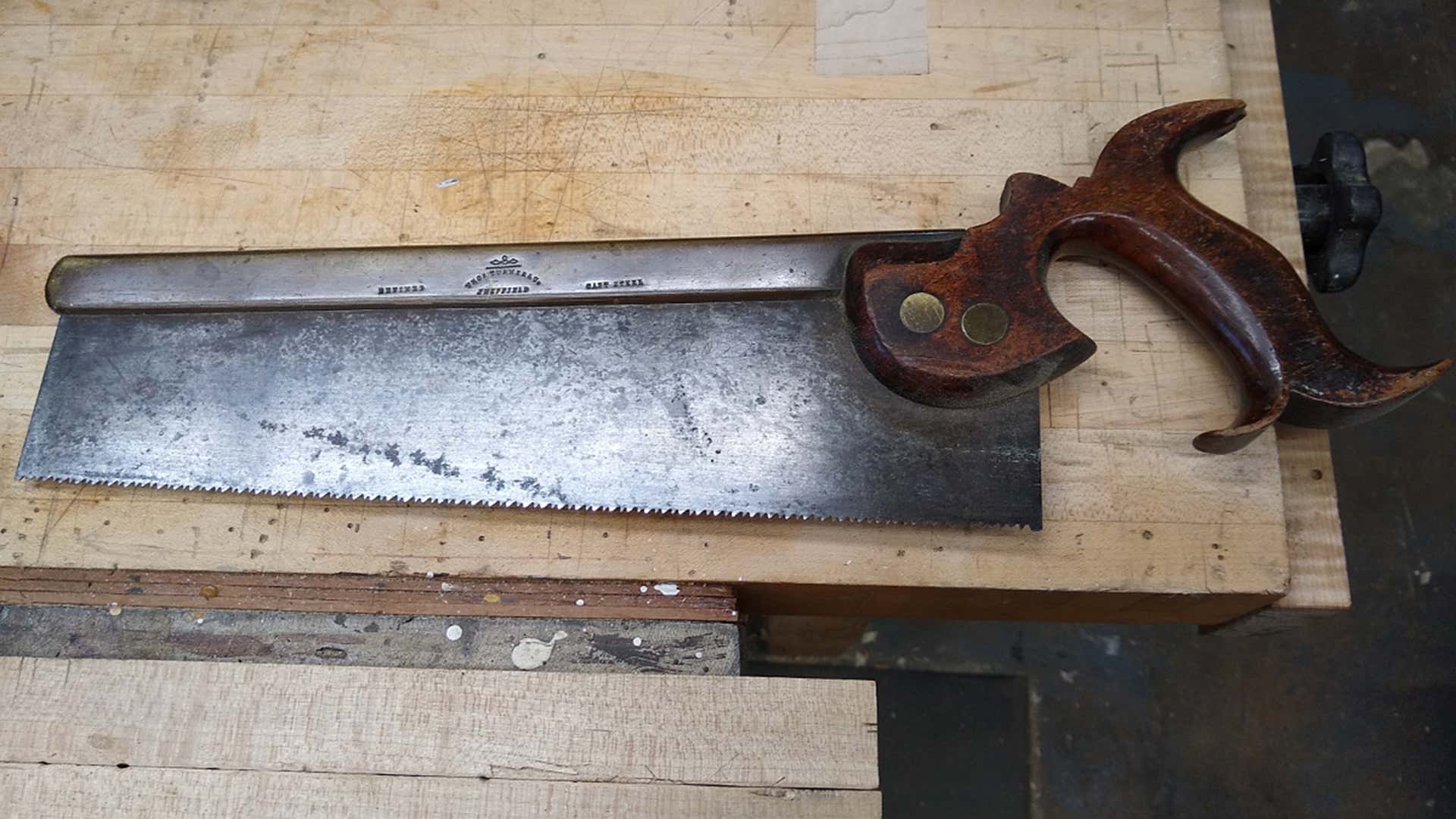 An old hand saw with a wooden handle. 有木柄的旧手锯。
