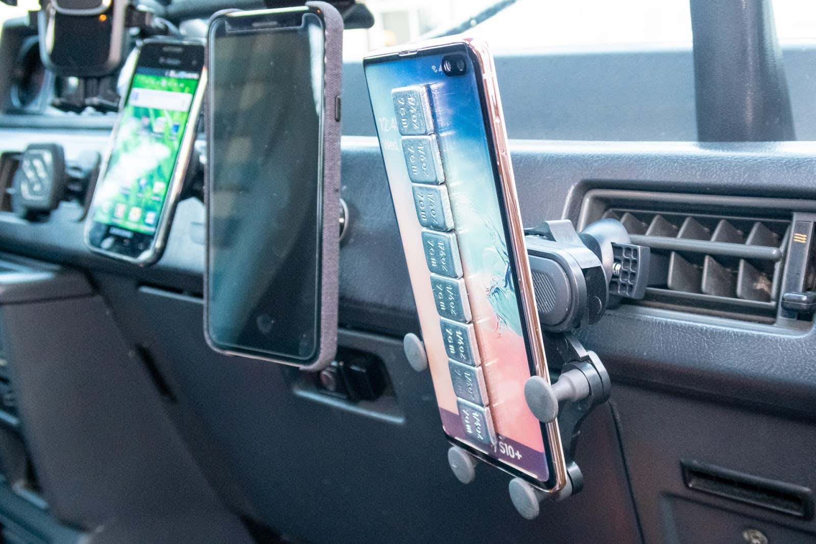 Car with three car phone mounts with phones 车有三个车载电话,安装有电话