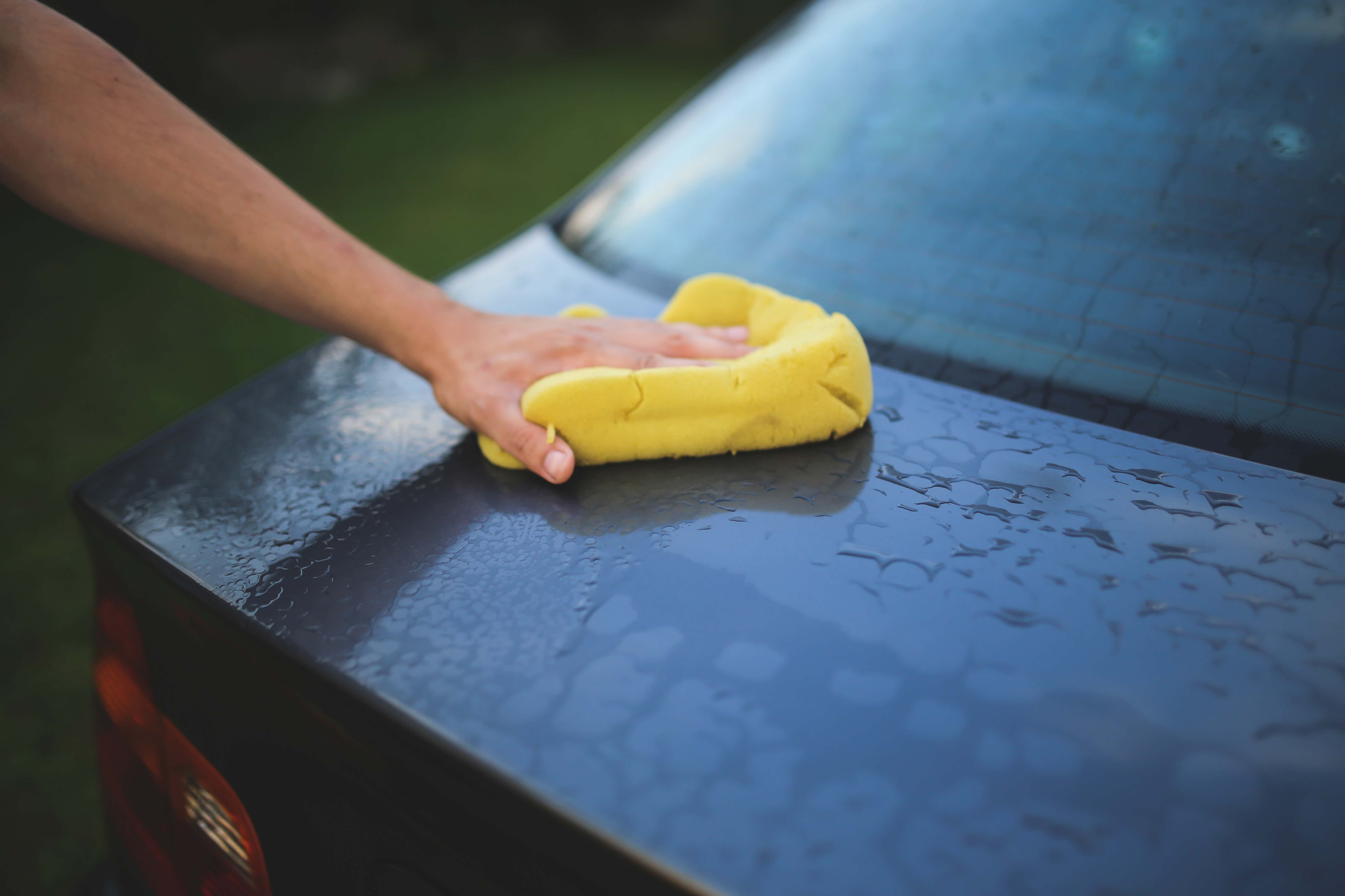 用黄色海绵洗一辆蓝色的汽车