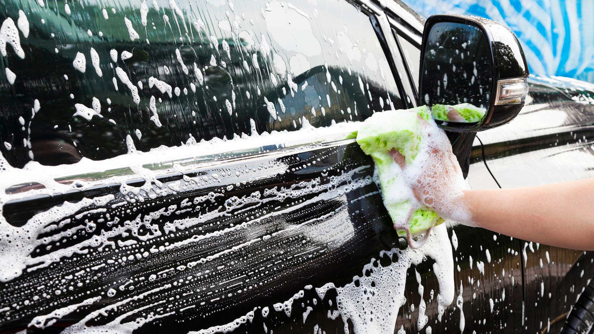 使用海绵的手擦拭肥皂车门。