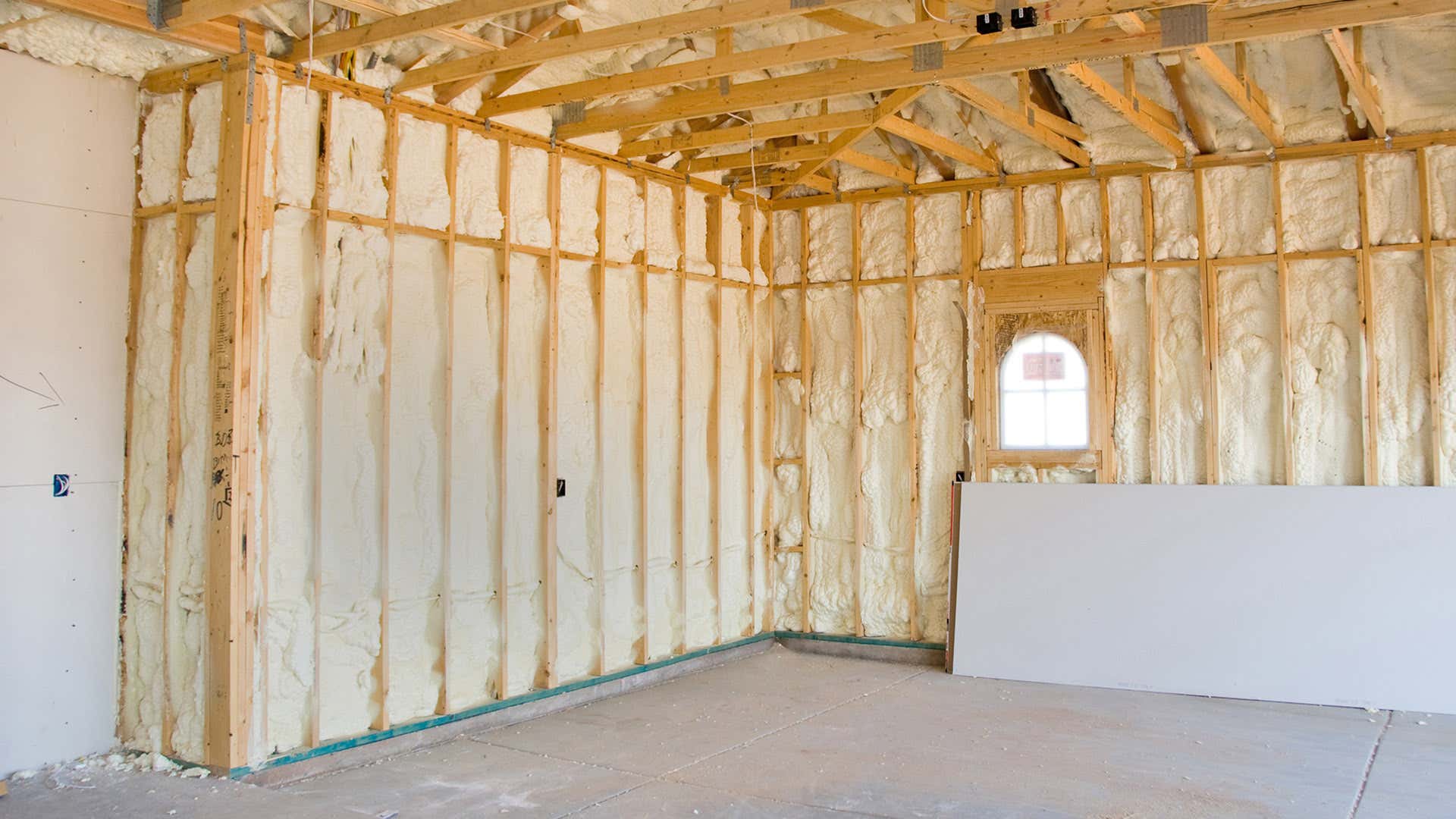 木质框架内的隔热层与车库中的混凝土地板形成对比。